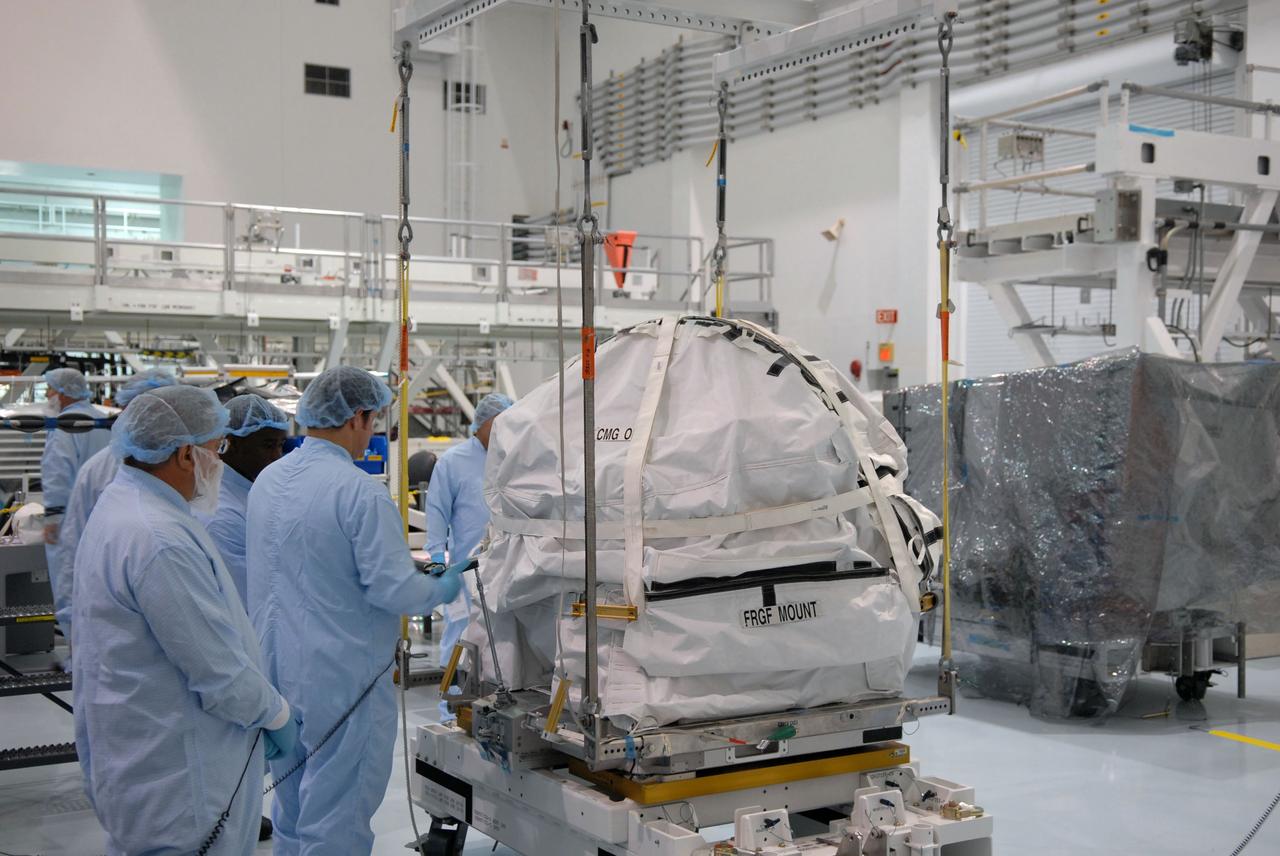 CAPE CANAVERAL, Fla. – In the Space Station Processing Facility at NASA's Kennedy Space Center in Florida, technicians prepare for a control moment gyroscope to be lifted by crane from a work stand. The gyroscope will be installed on an EXPRESS Logistics Carrier for flight. The carrier is part of the STS-129 payload on space shuttle Atlantis, which will deliver to the International Space Station two spare gyroscopes, two nitrogen tank assemblies, two pump modules, an ammonia tank assembly and a spare latching end effector for the station's robotic arm. STS-129 is targeted to launch Nov. 12. Photo credit: NASA/Jim Grossmann