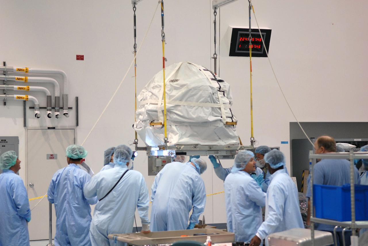 CAPE CANAVERAL, Fla. – In the Space Station Processing Facility at NASA's Kennedy Space Center in Florida, technicians check the bottom of a control moment gyroscope as it is lifted slowly by crane from a work stand. The gyroscope will be installed on an EXPRESS Logistics Carrier for flight.  The carrier is part of the STS-129 payload on space shuttle Atlantis, which will deliver to the International Space Station two spare gyroscopes, two nitrogen tank assemblies, two pump modules, an ammonia tank assembly and a spare latching end effector for the station's robotic arm. STS-129 is targeted to launch Nov. 12. Photo credit: NASA/Jim Grossmann