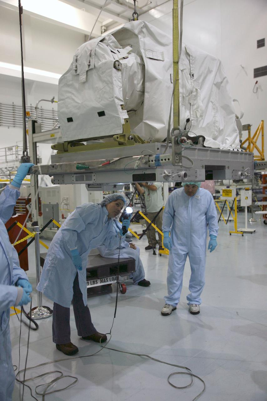 CAPE CANAVERAL, Fla. – In the Space Station Processing Facility at NASA's Kennedy Space Center in Florida, technicians check the bottom of a latching end effector being lifted by crane from a work stand. The effector will be installed on an EXPRESS Logistics Carrier for flight.  The carrier is part of the STS-129 payload on space shuttle Atlantis, which will deliver to the International Space Station two spare gyroscopes, two nitrogen tank assemblies, two pump modules, an ammonia tank assembly and a spare latching end effector for the station's robotic arm. STS-129 is targeted to launch Nov. 12. Photo credit: NASA/Dimitri Gerondidakis
