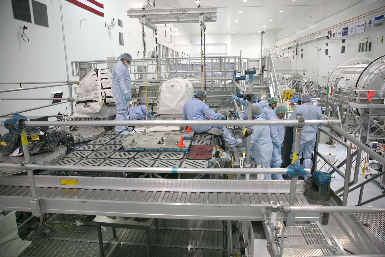 CAPE CANAVERAL, Fla. – In the Space Station Processing Facility at NASA's Kennedy Space Center in Florida, technicians prepare to secure a latching end effector to the EXPRESS Logistics Carrier on which it is being installed for flight. The carrier is part of the STS-129 payload on space shuttle Atlantis, which will deliver to the International Space Station two spare gyroscopes, two nitrogen tank assemblies, two pump modules, an ammonia tank assembly and a spare latching end effector for the station's robotic arm. STS-129 is targeted to launch Nov. 12. Photo credit: NASA/Dimitri Gerondidakis