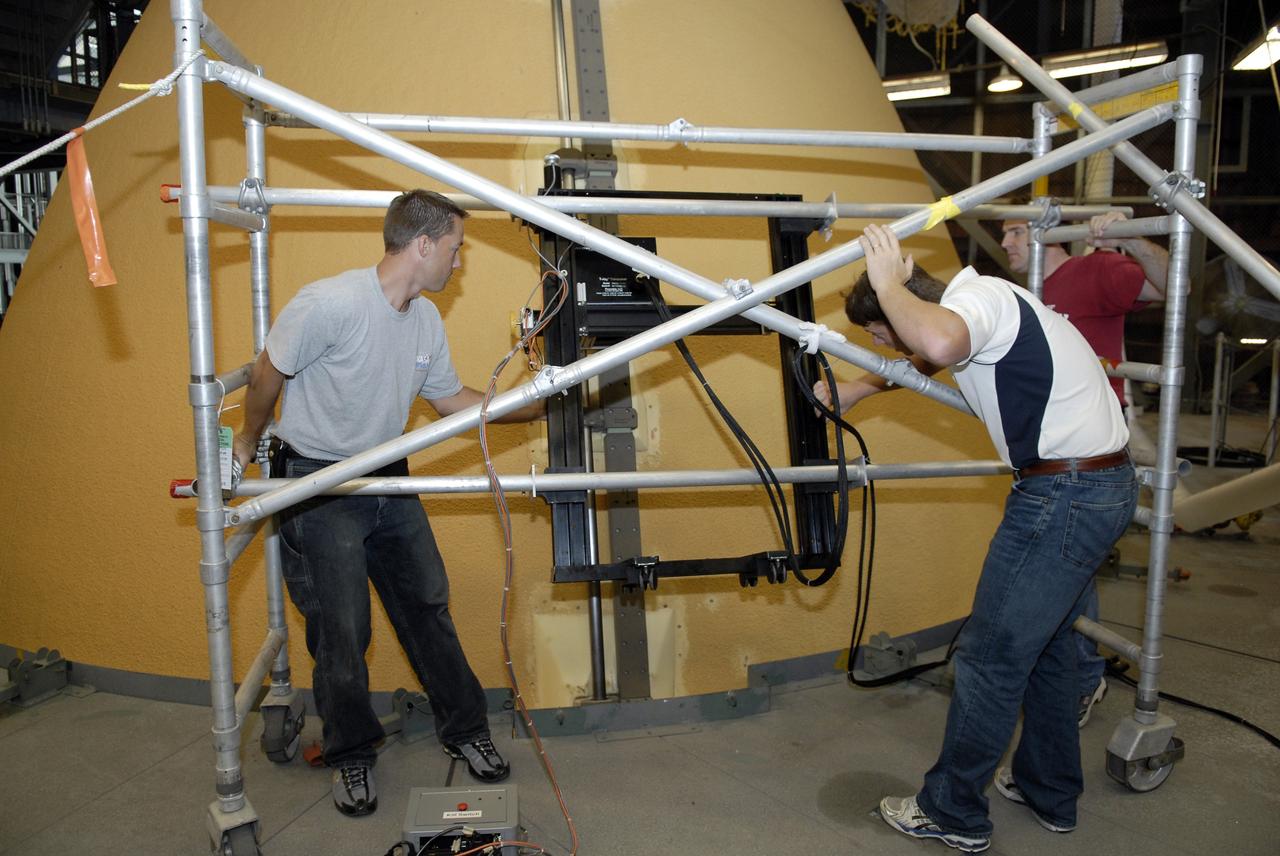 CAPE CANAVERAL, Fla. – In the Vehicle Assembly Building at NASA's Kennedy Space Center’s in Florida, technicians set up equipment that will be used to conduct terahertz scans of five ice frost ramps on the external fuel tank, designated ET-133, for space shuttle Atlantis’ STS-129 mission.  The ice frost ramps are made from foam insulation and cover brackets that hold pressurization lines on the outside of the external tank. Terahertz scans are wave frequency analysis in the infrared band that can see through the foam insulation to help look for any voids or pockets where the foam is not bonded to the metal primer. The ramps being scanned were on the top part of the tank in the same area where foam came off during the last two shuttle launches. The data will be used to help assess whether foam on ET-132, the fuel tank attached to shuttle Discovery at Kennedy’s Launch Pad 39A, is fit for its flight on the STS-128 mission to the International Space Station. Photo credit: NASA/Kim Shiflett