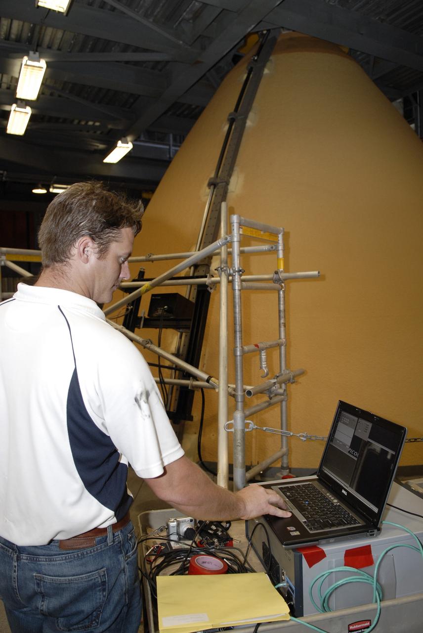 CAPE CANAVERAL, Fla. – In the Vehicle Assembly Building at NASA's Kennedy Space Center’s in Florida, a technician conducts terahertz scans of five ice frost ramps on the external fuel tank, designated ET-133, for space shuttle Atlantis’ STS-129 mission.  The ice frost ramps are made from foam insulation and cover brackets that hold pressurization lines on the outside of the external tank. Terahertz scans are wave frequency analysis in the infrared band that can see through the foam insulation to help look for any voids or pockets where the foam is not bonded to the metal primer. The ramps being scanned were on the top part of the tank in the same area where foam came off during the last two shuttle launches. The data will be used to help assess whether foam on ET-132, the fuel tank attached to shuttle Discovery at Kennedy’s Launch Pad 39A, is fit for its flight on the STS-128 mission to the International Space Station. Photo credit: NASA/Kim Shiflett