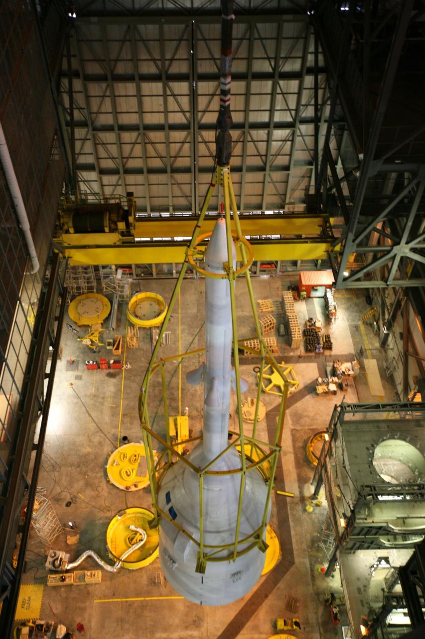 CAPE CANAVERAL, Fla. – In the Vehicle Assembly Building's High Bay 4, assembly of the Ares I-X rocket nears completion. The yellow framework, nicknamed the "birdcage," lifts Super Stack 5. The stack will be positioned on top of the segments already in place on the mobile launcher platform in High Bay 3, completing assembly of the 327-foot-tall rocket.  Five super stacks make up the rocket's upper stage that is integrated with the four-segment solid rocket booster first stage. Ares I-X is the test vehicle for the Ares I, which is part of the Constellation Program to return men to the moon and beyond. The Ares I-X flight test is targeted for Oct. 31, pending formal NASA Headquarters approval. Photo credit: NASA/Dimitri Gerondidakis