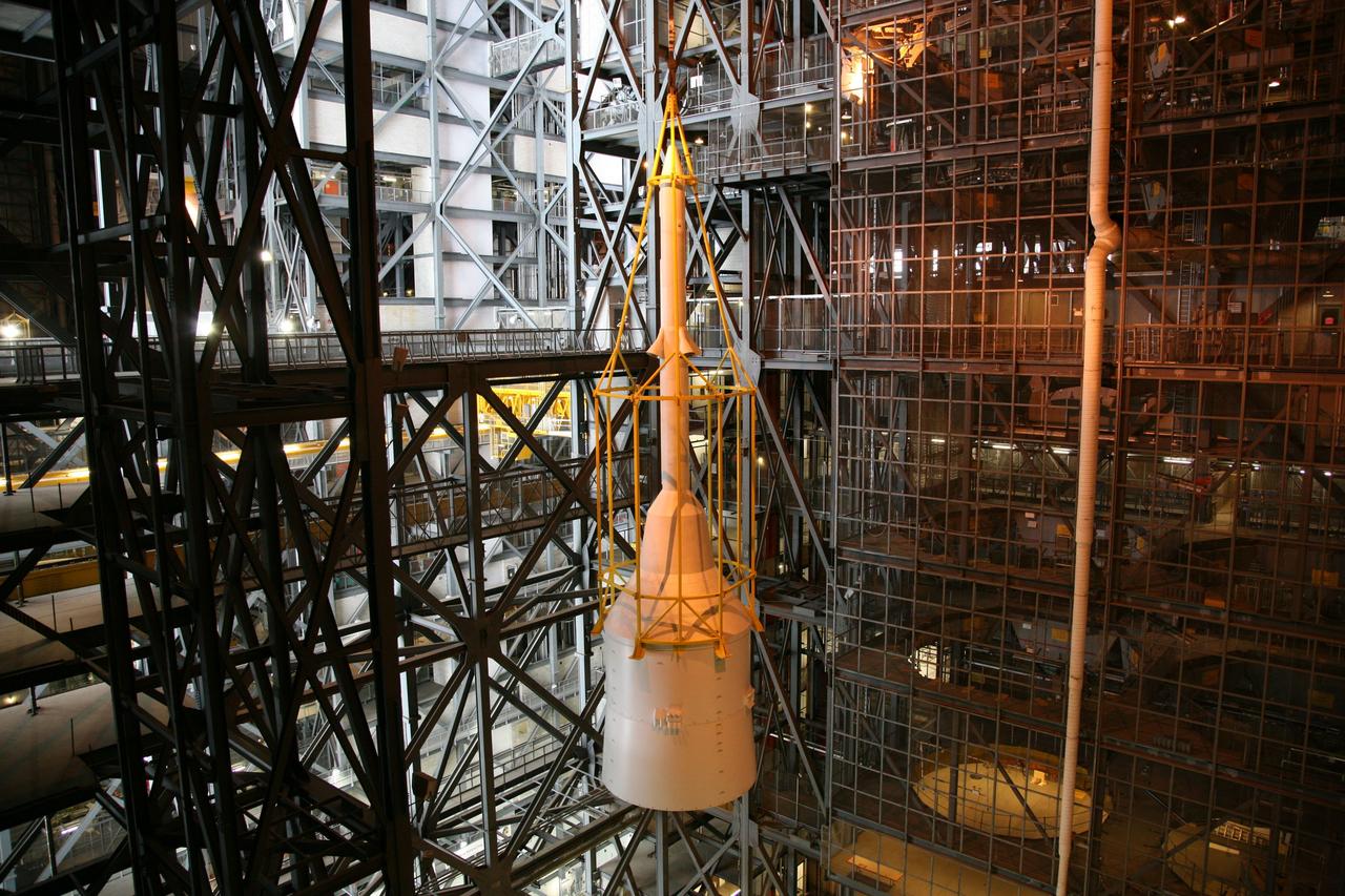 CAPE CANAVERAL, Fla. – In the Vehicle Assembly Building's High Bay 4, assembly of the Ares I-X rocket nears completion. The yellow framework, nicknamed the "birdcage," lifts Super Stack 5 toward an opening at the 16th floor crossover into the transfer aisle. The stack will be positioned on top of the segments already in place on the mobile launcher platform in High Bay 3, completing assembly of the 327-foot-tall rocket.  Five super stacks make up the rocket's upper stage that is integrated with the four-segment solid rocket booster first stage. Ares I-X is the test vehicle for the Ares I, which is part of the Constellation Program to return men to the moon and beyond. The Ares I-X flight test is targeted for Oct. 31, pending formal NASA Headquarters approval. Photo credit: NASA/Dimitri Gerondidakis