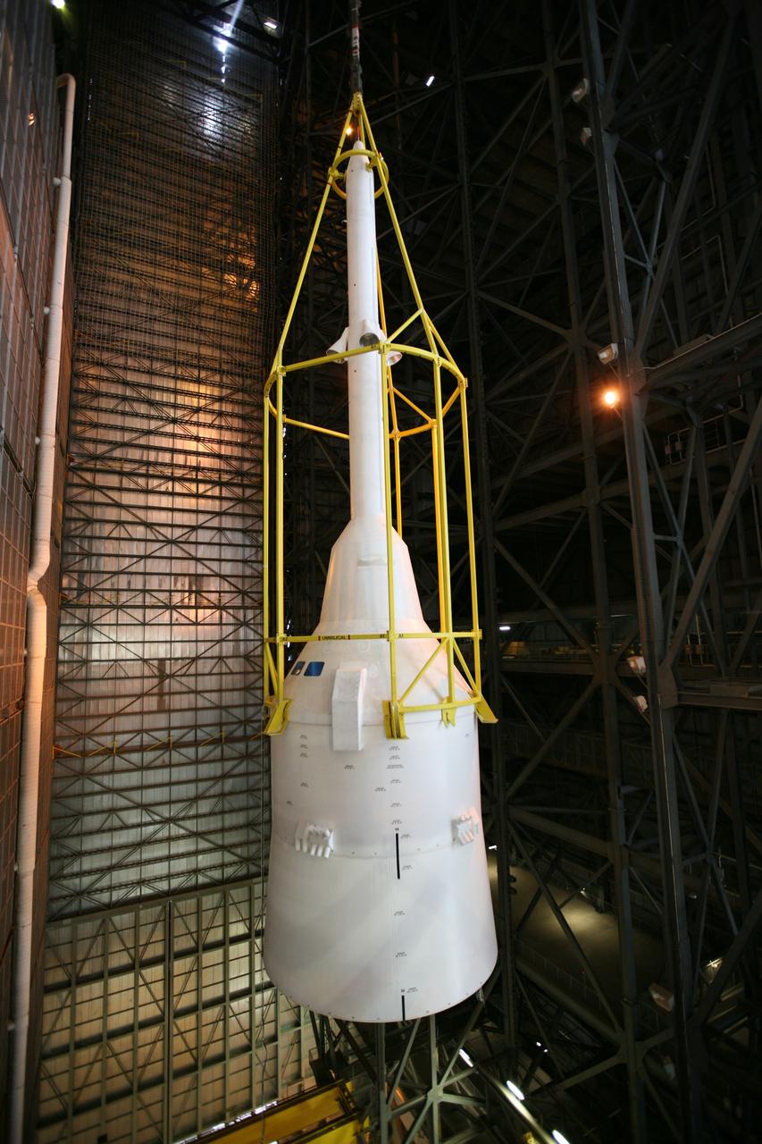 CAPE CANAVERAL, Fla. – In the Vehicle Assembly Building's High Bay 4, assembly of the Ares I-X rocket nears completion. The yellow framework, nicknamed the "birdcage," lifts Super Stack 5 toward an opening at the 16th floor crossover into the transfer aisle. The stack will be positioned on top of the segments already in place on the mobile launcher platform in High Bay 3, completing assembly of the 327-foot-tall rocket.  Five super stacks make up the rocket's upper stage that is integrated with the four-segment solid rocket booster first stage. Ares I-X is the test vehicle for the Ares I, which is part of the Constellation Program to return men to the moon and beyond. The Ares I-X flight test is targeted for Oct. 31, pending formal NASA Headquarters approval. Photo credit: NASA/Dimitri Gerondidakis