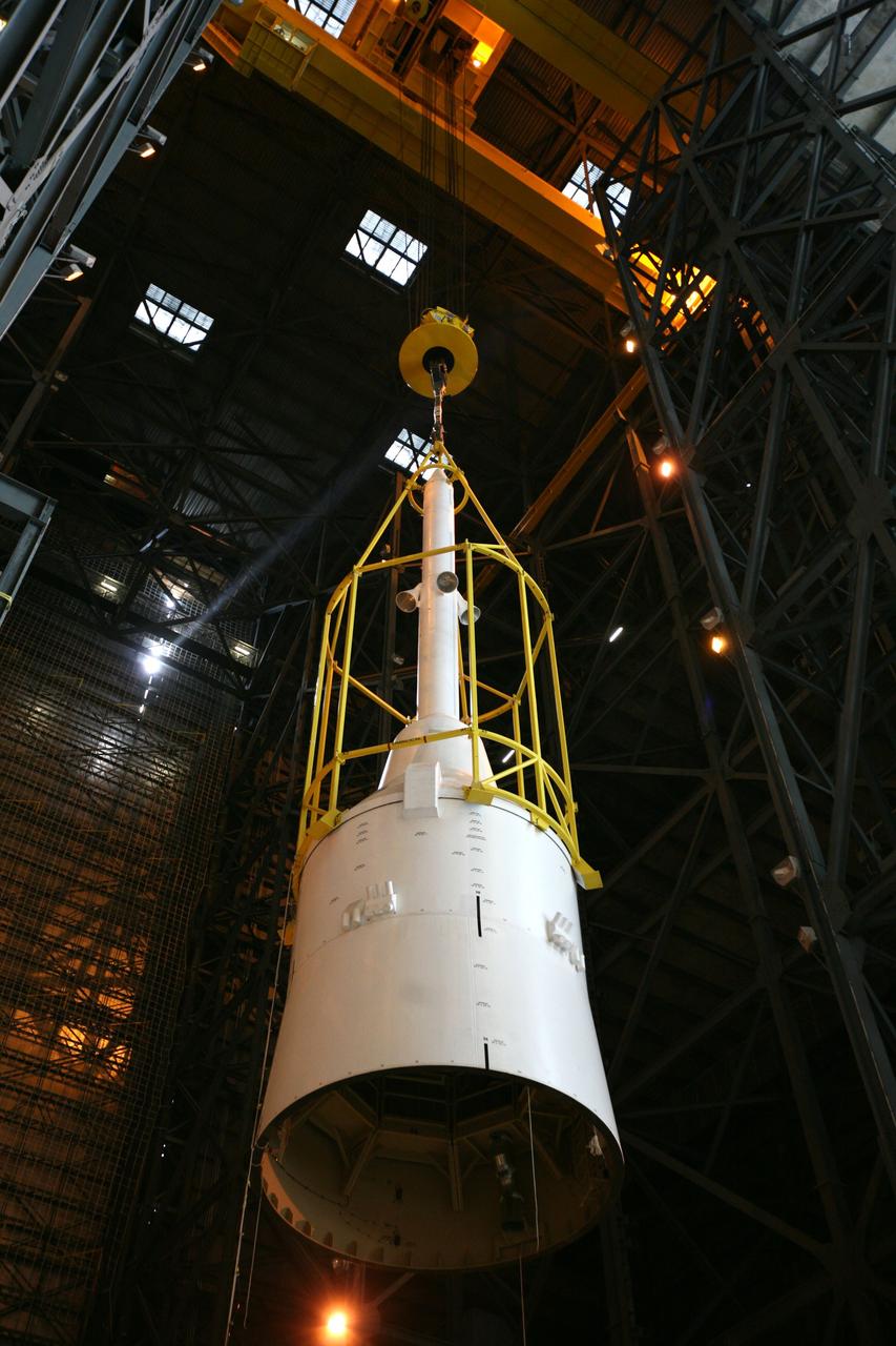 CAPE CANAVERAL, Fla. – In the Vehicle Assembly Building's High Bay 4, assembly of the Ares I-X rocket nears completion. The yellow framework, nicknamed the "birdcage," lifts Super Stack 5 toward an opening at the 16th floor crossover into the transfer aisle. The stack will be positioned on top of the segments already in place on the mobile launcher platform in High Bay 3, completing assembly of the 327-foot-tall rocket.  Five super stacks make up the rocket's upper stage that is integrated with the four-segment solid rocket booster first stage. Ares I-X is the test vehicle for the Ares I, which is part of the Constellation Program to return men to the moon and beyond. The Ares I-X flight test is targeted for Oct. 31, pending formal NASA Headquarters approval. Photo credit: NASA/Dimitri Gerondidakis