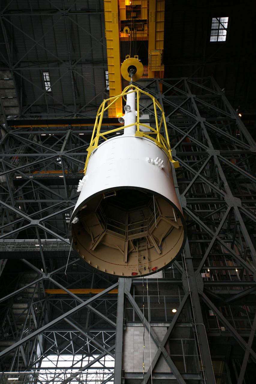 CAPE CANAVERAL, Fla. – In the Vehicle Assembly Building's transfer aisle, assembly of the Ares I-X rocket nears completion. The yellow framework, nicknamed the "birdcage," moves Super Stack 5 from High Bay 4 over the transfer aisle. The stack will be positioned on top of the segments already in place on the mobile launcher platform in High Bay 3, completing assembly of the 327-foot-tall rocket.  Five super stacks make up the rocket's upper stage that is integrated with the four-segment solid rocket booster first stage. Ares I-X is the test vehicle for the Ares I, which is part of the Constellation Program to return men to the moon and beyond. The Ares I-X flight test is targeted for Oct. 31, pending formal NASA Headquarters approval. Photo credit: NASA/Dimitri Gerondidakis