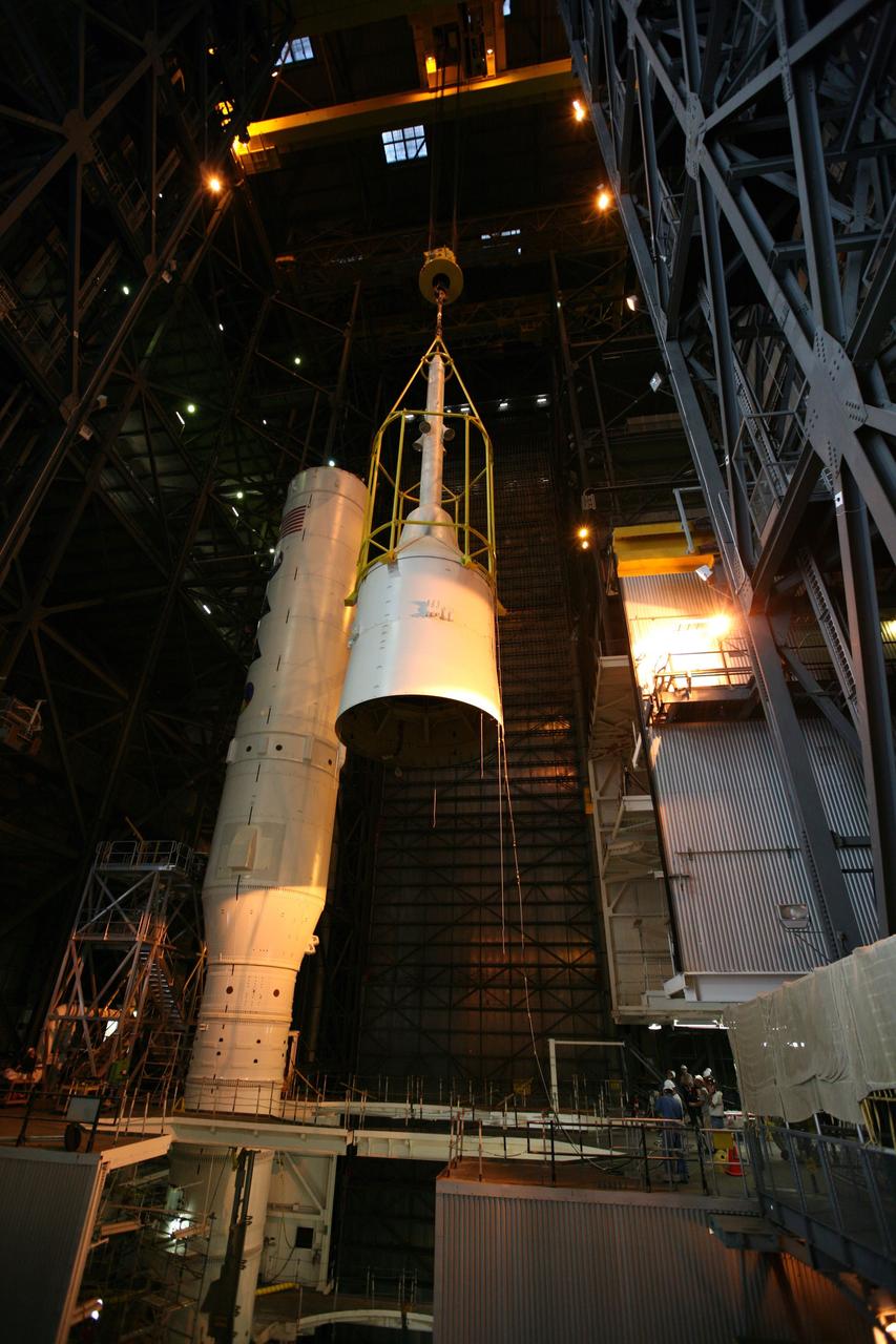 CAPE CANAVERAL, Fla. – In the Vehicle Assembly Building's High Bay 3, assembly of the Ares I-X rocket nears completion. The yellow framework, nicknamed the "birdcage," lifts Super Stack 5 to the top of the segments already in place on the mobile launcher platform. Once in position, assembly of the rocket will be complete. The 327-foot-tall rocket is one of the largest processed in the bay, rivaling the height of the Apollo Program's 364-foot-tall Saturn V. Five super stacks make up the rocket's upper stage that is integrated with the four-segment solid rocket booster first stage. Ares I-X is the test vehicle for the Ares I, which is part of the Constellation Program to return men to the moon and beyond. The Ares I-X flight test is targeted for Oct. 31, pending formal NASA Headquarters approval. Photo credit: NASA/Dimitri Gerondidakis