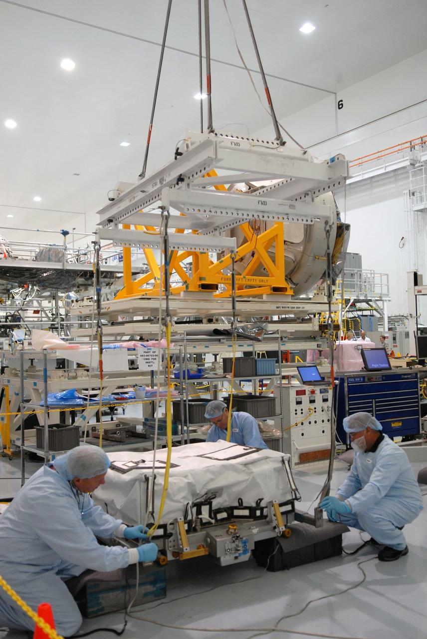 CAPE CANAVERAL, Fla. – In the Space Station Processing Facility at NASA's Kennedy Space Center in Florida, technicians prepare for a battery charge-discharge unit to be lifted by crane from a work stand. The unit will be installed on an EXPRESS Logistics Carrier for flight. The carrier is part of the STS-129 payload on space shuttle Atlantis, which will deliver to the International Space Station two spare gyroscopes, two nitrogen tank assemblies, two pump modules, an ammonia tank assembly and a spare latching end effector for the station's robotic arm. STS-129 is targeted to launch Nov. 12. Photo credit: NASA/Jim Grossmann