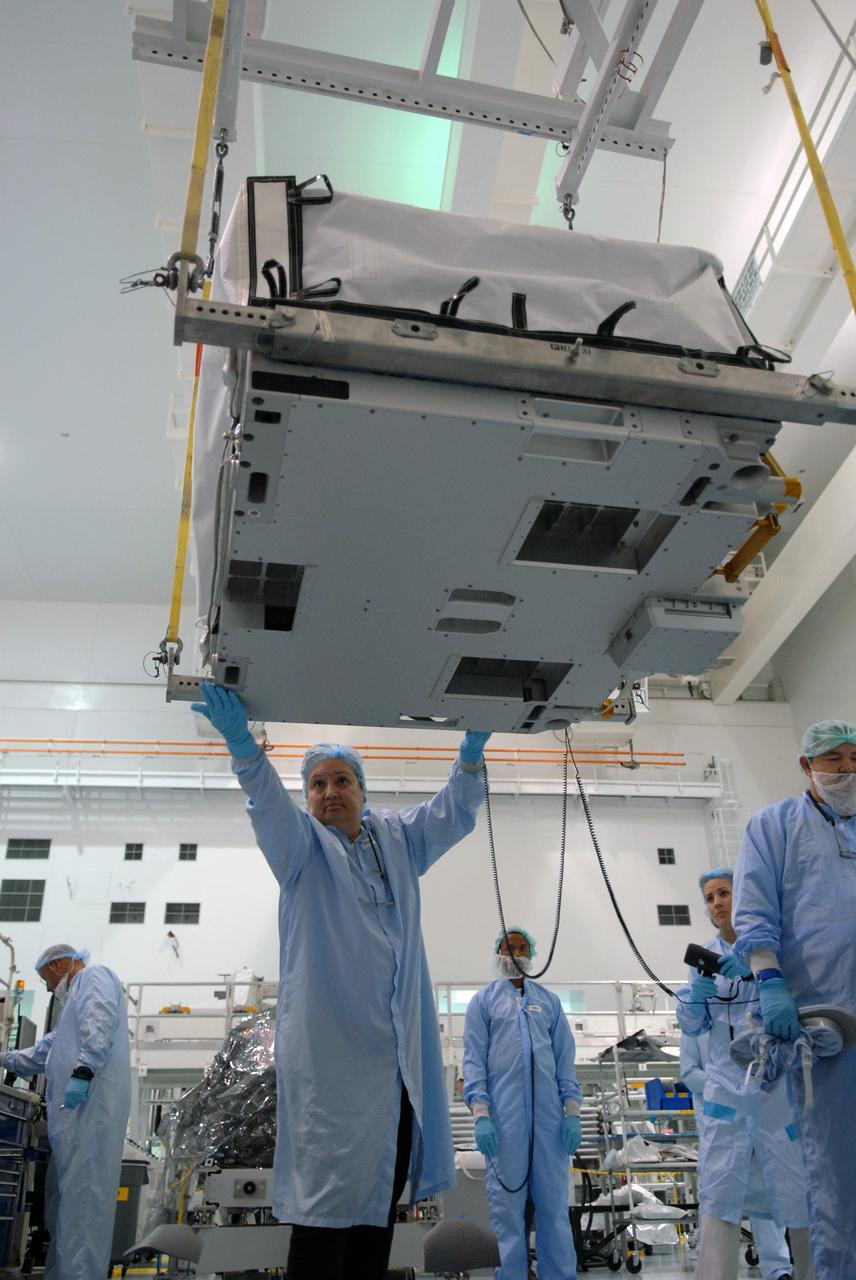 CAPE CANAVERAL, Fla. – In the Space Station Processing Facility at NASA's Kennedy Space Center in Florida, a technician checks the bottom of a battery charge-discharge unit being lifted by crane from a work stand. The unit will be installed on an EXPRESS Logistics Carrier for flight. The carrier is part of the STS-129 payload on space shuttle Atlantis, which will deliver to the International Space Station two spare gyroscopes, two nitrogen tank assemblies, two pump modules, an ammonia tank assembly and a spare latching end effector for the station's robotic arm. STS-129 is targeted to launch Nov. 12. Photo credit: NASA/Jim Grossmann