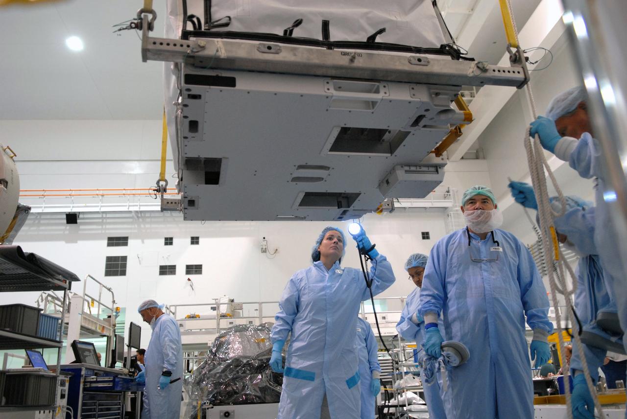 CAPE CANAVERAL, Fla. – In the Space Station Processing Facility at NASA's Kennedy Space Center in Florida, a technician inspects a battery charge-discharge unit being lifted by crane from a work stand. The unit will be installed on an EXPRESS Logistics Carrier for flight. The carrier is part of the STS-129 payload on space shuttle Atlantis, which will deliver to the International Space Station two spare gyroscopes, two nitrogen tank assemblies, two pump modules, an ammonia tank assembly and a spare latching end effector for the station's robotic arm. STS-129 is targeted to launch Nov. 12. Photo credit: NASA/Jim Grossmann