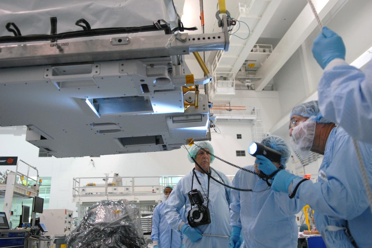 CAPE CANAVERAL, Fla. – In the Space Station Processing Facility at NASA's Kennedy Space Center in Florida, a technician inspects a battery charge-discharge unit being lifted by crane from a work stand. The unit will be installed on an EXPRESS Logistics Carrier for flight. The carrier is part of the STS-129 payload on space shuttle Atlantis, which will deliver to the International Space Station two spare gyroscopes, two nitrogen tank assemblies, two pump modules, an ammonia tank assembly and a spare latching end effector for the station's robotic arm. STS-129 is targeted to launch Nov. 12. Photo credit: NASA/Jim Grossmann