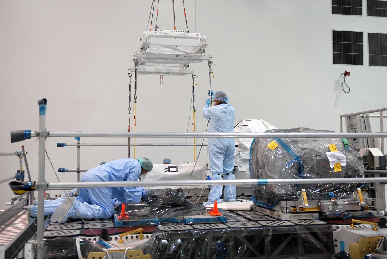 CAPE CANAVERAL, Fla. – In the Space Station Processing Facility at NASA's Kennedy Space Center in Florida, technicians release a battery charge-discharge unit from a crane which carried it to an EXPRESS Logistics Carrier. The unit will be installed on the carrier for flight.  The carrier is part of the STS-129 payload on space shuttle Atlantis, which will deliver to the International Space Station two spare gyroscopes, two nitrogen tank assemblies, two pump modules, an ammonia tank assembly and a spare latching end effector for the station's robotic arm. STS-129 is targeted to launch Nov. 12. Photo credit: NASA/Jim Grossmann