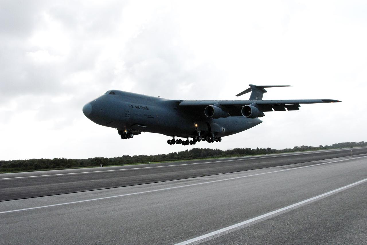 CAPE CANAVERAL, Fla. – The U.S. Air Force C-5 prepares to land on NASA Kennedy Space Center's Shuttle Landing Facility.  The aircraft carries the Express Logistics Carrier 4, or ELC4, part of the payload for the STS-133 mission.  Space shuttle Endeavour will deliver the ELC4 and ELC3 with critical spare components to the International Space Station on the mission.  Endeavour's launch is targeted for late July in 2010.  Photo credit: NASA/Amanda Diller