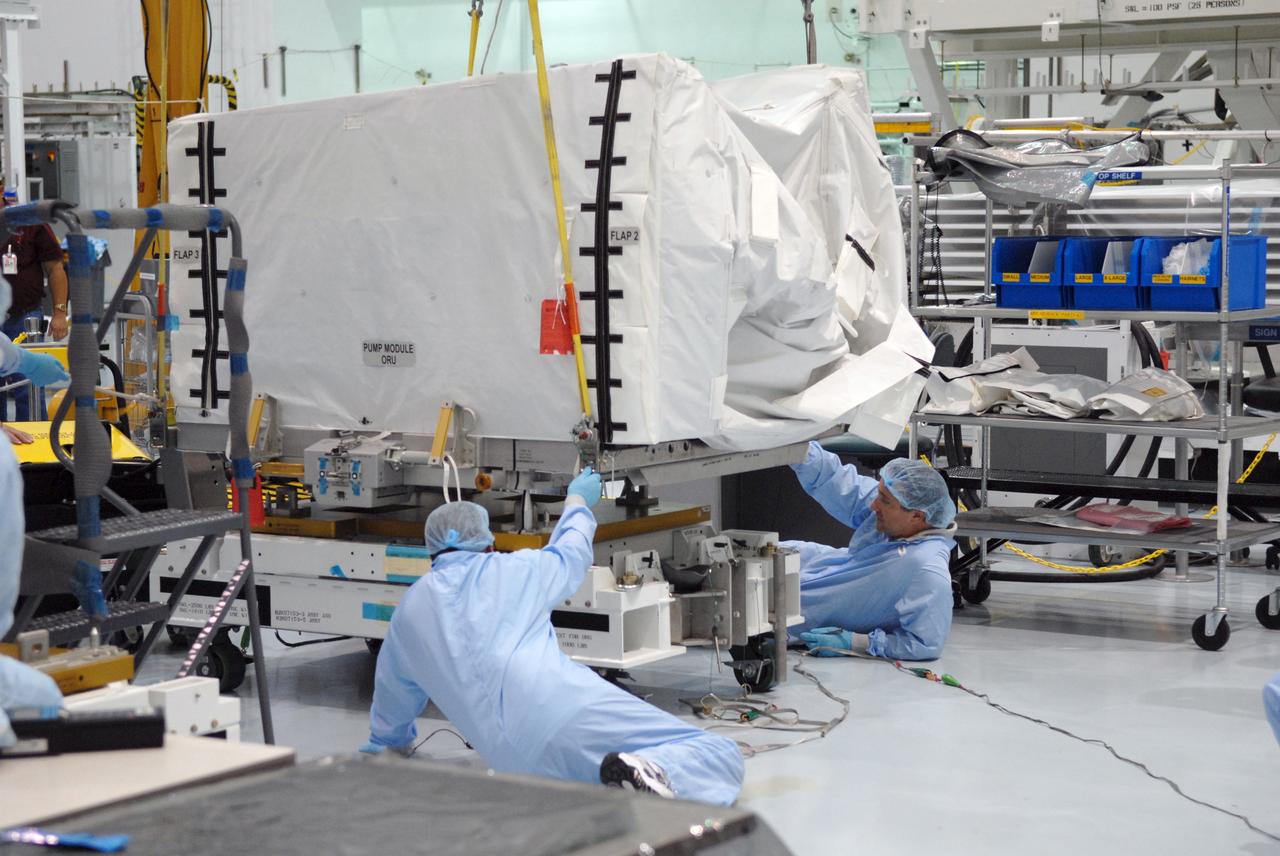 CAPE CANAVERAL, Fla. – In the space Station Processing Facility at NASA's Kennedy Space Center in Florida, technicians attach the overhead crane to the pump module orbital replacement unit.  The crane will lift and move the equipment to the Express Logistics Carrier 1, or ELC-1. The carrier is part of the STS-129 payload on space shuttle Atlantis, which will deliver to the International Space Station two spare gyroscopes, two nitrogen tank assemblies, two pump modules, an ammonia tank assembly and a spare latching end effector for the station's robotic arm. STS-129 is targeted to launch Nov. 12. Photo credit: NASA/Jim Grossmann