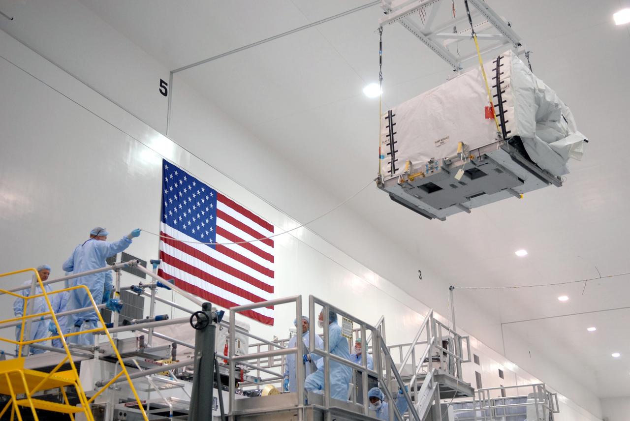CAPE CANAVERAL, Fla. – In the space Station Processing Facility at NASA's Kennedy Space Center in Florida, the pump module orbital replacement unit is moved to the Express Logistics Carrier 1, or ELC-1, for installation. The carrier is part of the STS-129 payload on space shuttle Atlantis, which will deliver to the International Space Station two spare gyroscopes, two nitrogen tank assemblies, two pump modules, an ammonia tank assembly and a spare latching end effector for the station's robotic arm. STS-129 is targeted to launch Nov. 12. Photo credit: NASA/Jim Grossmann