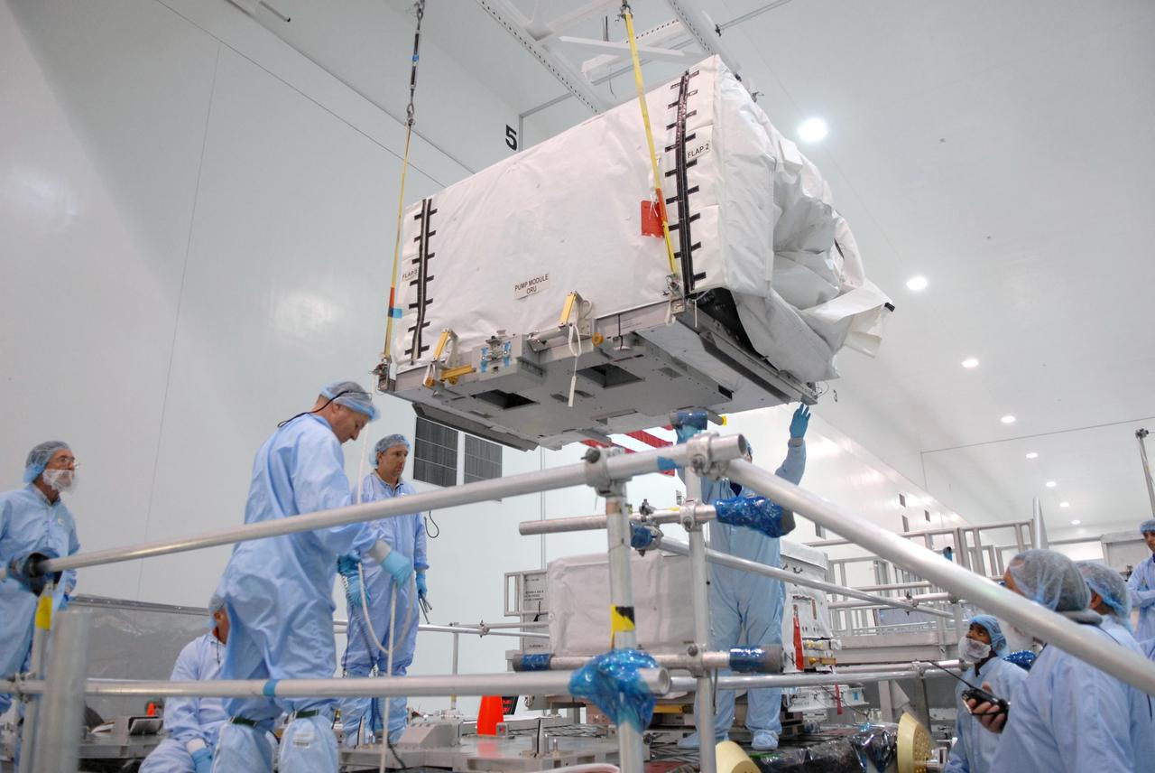 CAPE CANAVERAL, Fla. – In the space Station Processing Facility at NASA's Kennedy Space Center in Florida, the pump module orbital replacement unit is lowered toward the Express Logistics Carrier 1, or ELC-1, for installation. The carrier is part of the STS-129 payload on space shuttle Atlantis, which will deliver to the International Space Station two spare gyroscopes, two nitrogen tank assemblies, two pump modules, an ammonia tank assembly and a spare latching end effector for the station's robotic arm. STS-129 is targeted to launch Nov. 12. Photo credit: NASA/Jim Grossmann