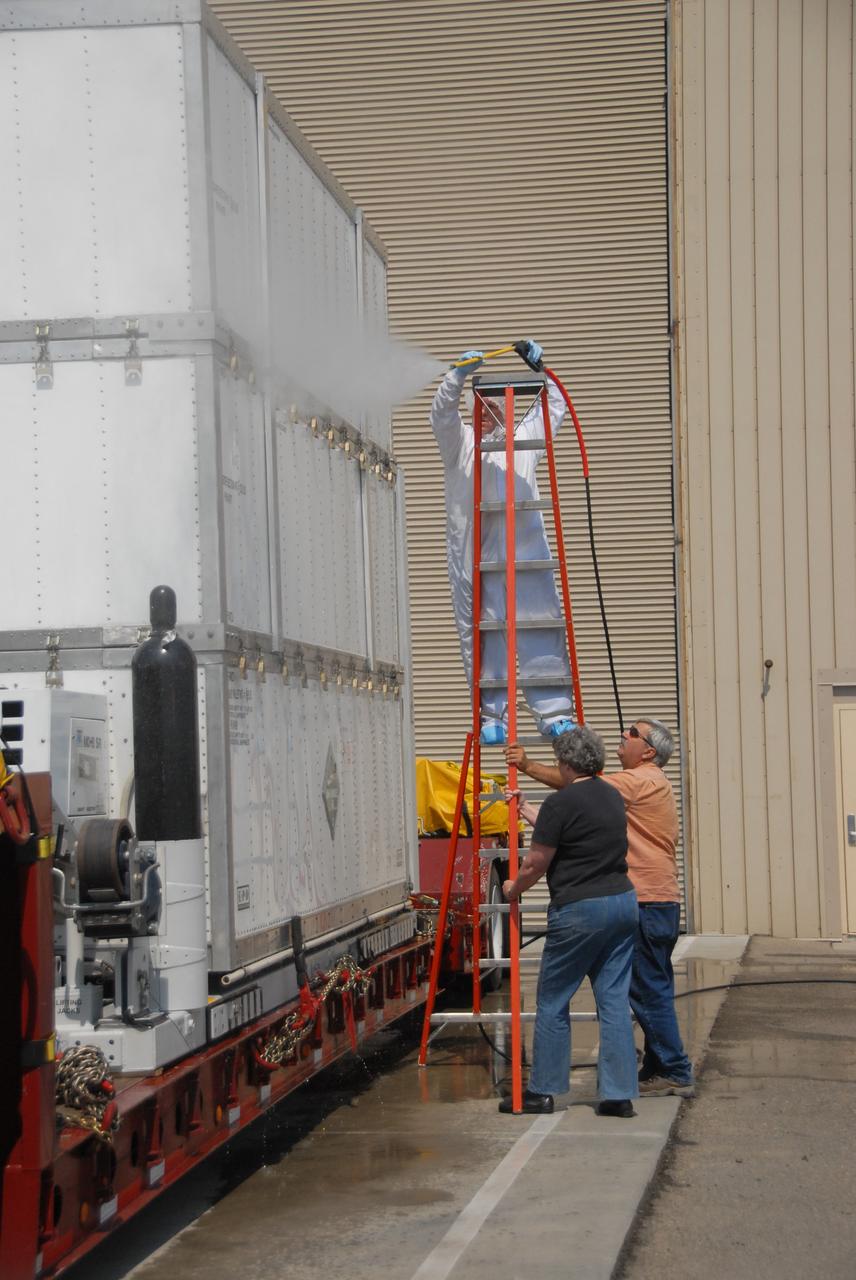 VANDENBERG AIR FORCE BASE, Calif. -- Outside the Astrotech payload processing facility on Vandenberg Air Force Base in California, workers clean the shipping container of NASA's Wide-field Infrared Survey Explorer, or WISE, spacecraft before moving it inside. The satellite will survey the entire sky at infrared wavelengths, creating a cosmic clearinghouse of hundreds of millions of objects, which will be catalogued, providing a vast storehouse of knowledge about the solar system, the Milky Way, and the universe. Launch is scheduled no earlier than Dec. 10. Photo credit: NASA/VAFB