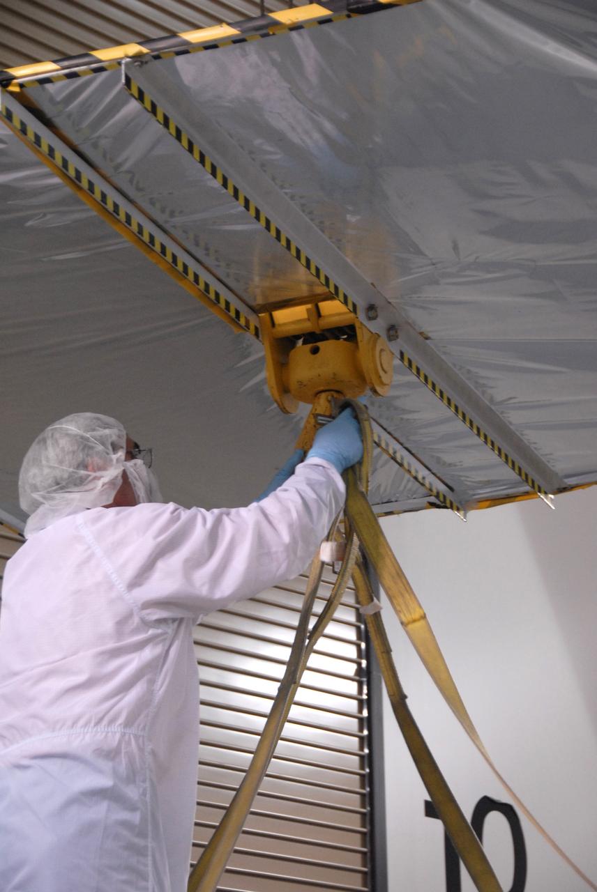 VANDENBERG AIR FORCE BASE, Calif. -- In the Astrotech payload processing facility at Vandenberg Air Force Base in California, workers prepare the overhead crane that will lift the shipping container from NASA's Wide-field Infrared Survey Explorer, or WISE, spacecraft.  The satellite will survey the entire sky at infrared wavelengths, creating a cosmic clearinghouse of hundreds of millions of objects,  which will be catalogued, providing a vast storehouse of knowledge about the solar system, the Milky Way, and the universe. Launch is scheduled no earlier than Dec. 10.  Photo credit: NASA/Doug Kolkow, VAFB