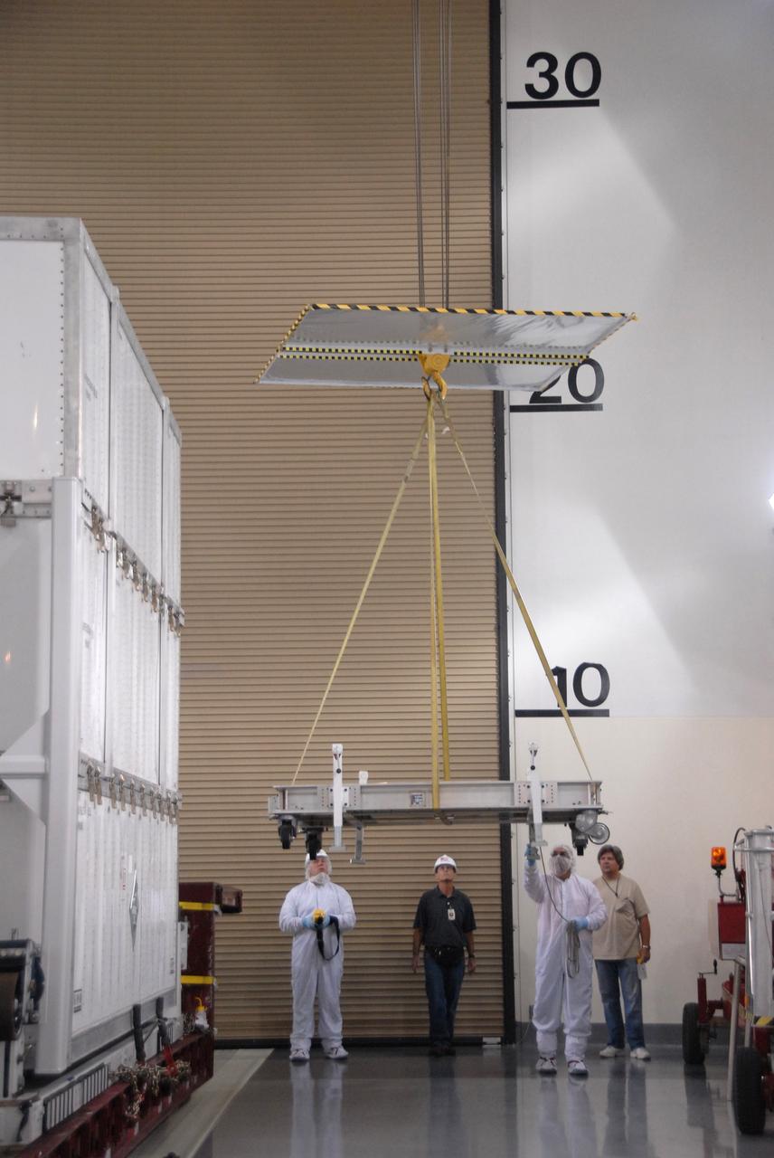 VANDENBERG AIR FORCE BASE, Calif. -- In the Astrotech payload processing facility at Vandenberg Air Force Base in California, workers raise the overhead crane that will be attached to the shipping container that covers NASA's Wide-field Infrared Survey Explorer, or WISE, spacecraft.  The satellite will survey the entire sky at infrared wavelengths, creating a cosmic clearinghouse of hundreds of millions of objects,  which will be catalogued, providing a vast storehouse of knowledge about the solar system, the Milky Way, and the universe. Launch is scheduled no earlier than Dec. 10.  Photo credit: NASA/Doug Kolkow, VAFB