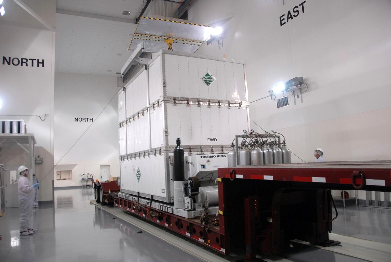 VANDENBERG AIR FORCE BASE, Calif. -- In the Astrotech payload processing facility at Vandenberg Air Force Base in California, workers lower the overhead crane onto the shipping container to remove it from around NASA's Wide-field Infrared Survey Explorer, or WISE, spacecraft.  The satellite will survey the entire sky at infrared wavelengths, creating a cosmic clearinghouse of hundreds of millions of objects,  which will be catalogued, providing a vast storehouse of knowledge about the solar system, the Milky Way, and the universe. Launch is scheduled no earlier than Dec. 10.  Photo credit: NASA/Doug Kolkow, VAFB