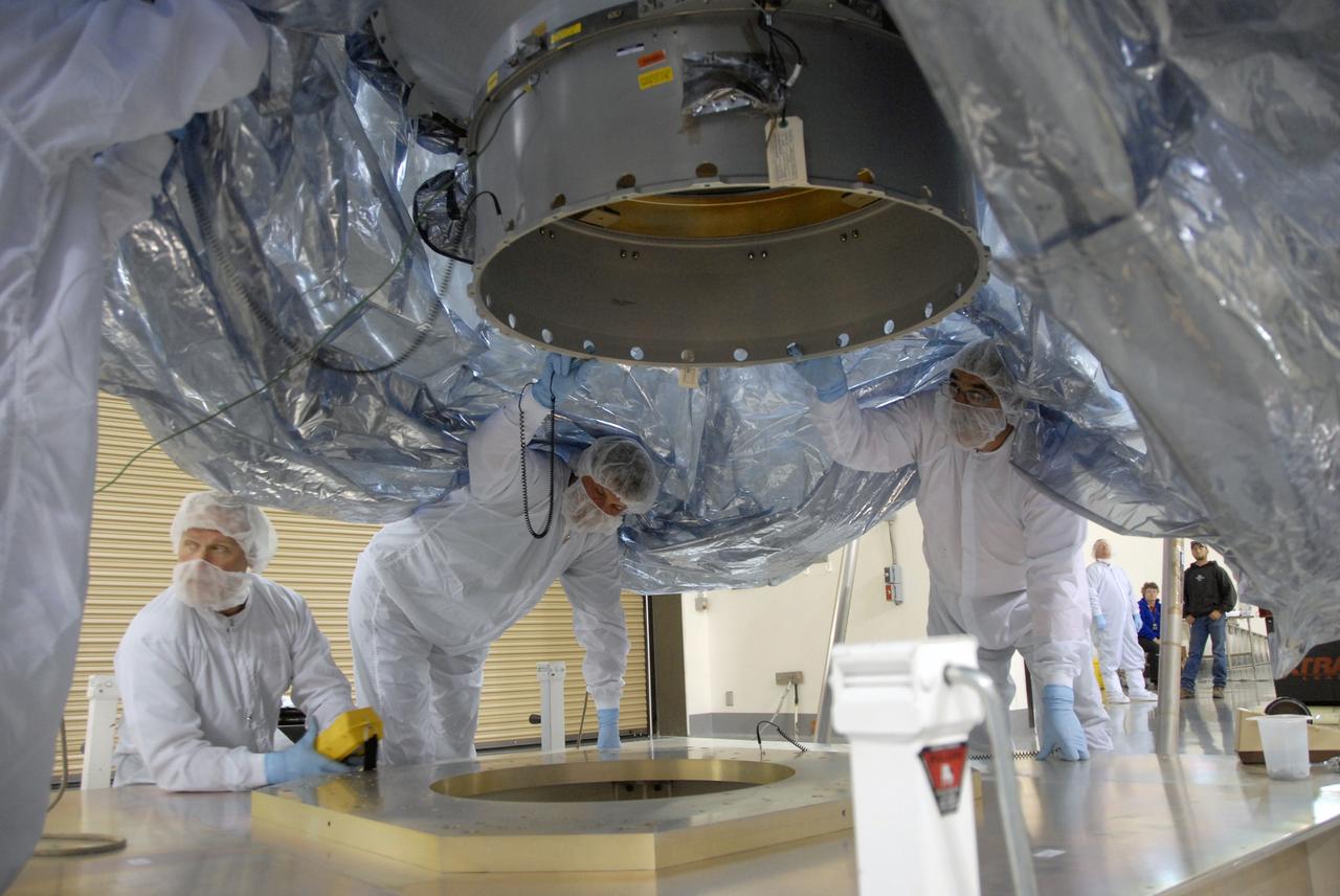VANDENBERG AIR FORCE BASE, Calif. -- In the Astrotech payload processing facility at Vandenberg Air Force Base in California, workers check the underside of NASA's Wide-field Infrared Survey Explorer, or WISE, spacecraft before it is lowered onto a stand.  The satellite will survey the entire sky at infrared wavelengths, creating a cosmic clearinghouse of hundreds of millions of objects,  which will be catalogued, providing a vast storehouse of knowledge about the solar system, the Milky Way, and the universe. Launch is scheduled no earlier than Dec. 10.  Photo credit: NASA/Doug Kolkow, VAFB
