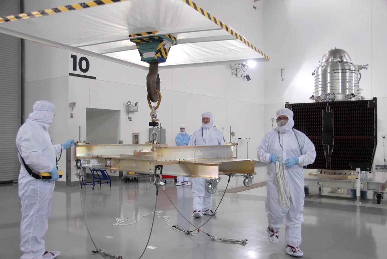VANDENBERG AIR FORCE BASE, Calif. -- At Vandenberg Air Force Base's Astrotech processing facility in California, workers maneuver the overhead crane that will lift NASA's Wide-field Infrared Survey Explorer, or WISE, spacecraft from the travel dolly to a work stand. The satellite will survey the entire sky at infrared wavelengths, creating a cosmic clearinghouse of hundreds of millions of objects,  which will be catalogued, providing a vast storehouse of knowledge about the solar system, the Milky Way, and the universe. Launch is scheduled no earlier than Dec. 10.  Photo credit: NASA/Moore, VAFB