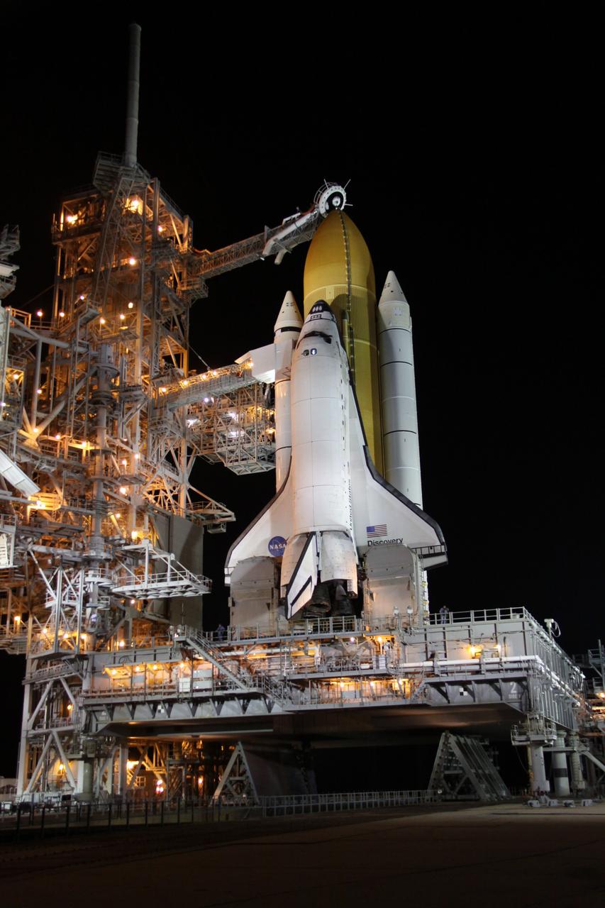 CAPE CANAVERAL, Fla. – On Launch Pad 39A at NASA's Kennedy Space Center in Florida, the oxygen vent hood, called the "beanie cap," is positioned above the external fuel tank of space shuttle Discovery following the rollback of the rotating service structure, or RSS, at left. The beanie cap is designed to vent gaseous oxygen vapors away from the shuttle. The rollback is preparation for Discovery's scheduled 1:36 a.m. EDT liftoff Aug. 25 on the STS-128 mission with a crew of seven. First motion was at 5:06 a.m. EDT and completed at 5:46 a.m. EDT. The service structure provides weather protection and access to the space shuttle at the launch pad. The 13-day mission will deliver a new crew member and 33,000 pounds of equipment to the International Space Station. The equipment includes science and storage racks, a freezer to store research samples, a new sleeping compartment and the COLBERT treadmill. STS-128 will be Discovery's 37th mission and the 30th shuttle flight dedicated to station assembly and maintenance. Photo credit: NASA/Troy Cryder