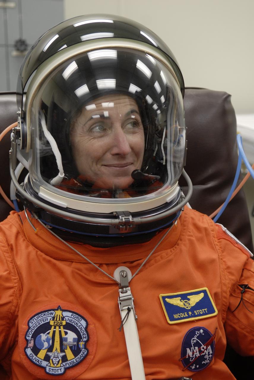CAPE CANAVERAL, Fla. – In the Operations and Checkout Building at NASA's Kennedy Space Center in Florida, STS-128 crew members put on their launch-and-entry suits before heading to the Astrovan for the 3.4-mile drive to Launch Pad 39A.  There, crew members will complete their suitup and enter space shuttle Discovery for the 1:36 a.m. EDT liftoff. Seen here is Mission Specialist Nicole Stott, checking communications in her helmet. The 13-day mission will deliver more than 7 tons of supplies, science racks and equipment, as well as additional environmental hardware to sustain six crew members on the International Space Station. The equipment includes a freezer to store research samples, a new sleeping compartment and the COLBERT treadmill.  The mission is the 128th in the Space Shuttle Program, the 37th flight of Discovery and the 30th station assembly flight.  Photo credit: NASA/Kim Shiflett