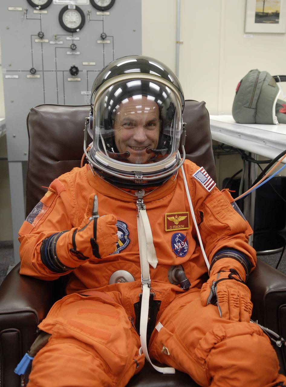 CAPE CANAVERAL, Fla. – In the Operations and Checkout Building at NASA's Kennedy Space Center in Florida, STS-128 crew members put on their launch-and-entry suits before heading to the Astrovan for the 3.4-mile drive to Launch Pad 39A. There, crew members will complete their suitup and enter space shuttle Discovery for the 1:36 a.m. EDT liftoff. Seen here, Commander Rick Sturckow signals his readiness for launch. The 13-day mission will deliver more than 7 tons of supplies, science racks and equipment, as well as additional environmental hardware to sustain six crew members on the International Space Station. The equipment includes a freezer to store research samples, a new sleeping compartment and the COLBERT treadmill. The mission is the 128th in the Space Shuttle Program, the 37th flight of Discovery and the 30th station assembly flight. Photo credit: NASA/Kim Shiflett