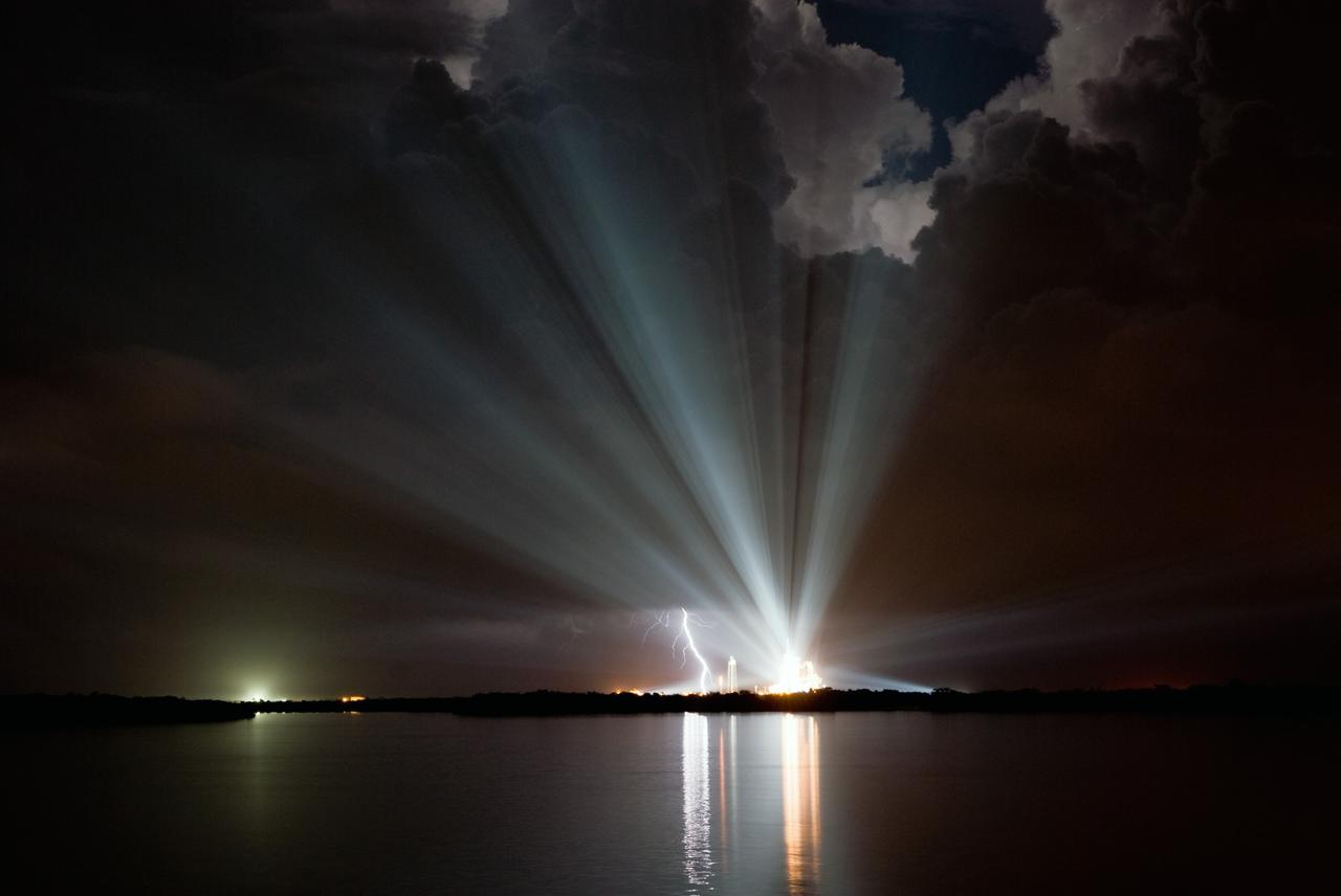 CAPE CANAVERAL, Fla. –  Xenon lights over Launch Pad 39A at NASA's Kennedy Space Center in Florida compete with the lightning strike seen to the left.  Space shuttle Discovery is on the pad waiting for a scheduled liftoff on the STS-128 mission.  Launch was scrubbed due to the weather conditions that violated the limitations for liftoff.  Another launch attempt was scheduled for 1:10 a.m. Aug. 26. Discovery's 13-day mission will deliver more than 7 tons of supplies, science racks and equipment, as well as additional environmental hardware to sustain six crew members on the International Space Station. The equipment includes a freezer to store research samples, a new sleeping compartment and the COLBERT treadmill.  The mission is the 128th in the Space Shuttle Program, the 37th flight of Discovery and the 30th station assembly flight.  Photo credit: NASA/Ben Cooper
