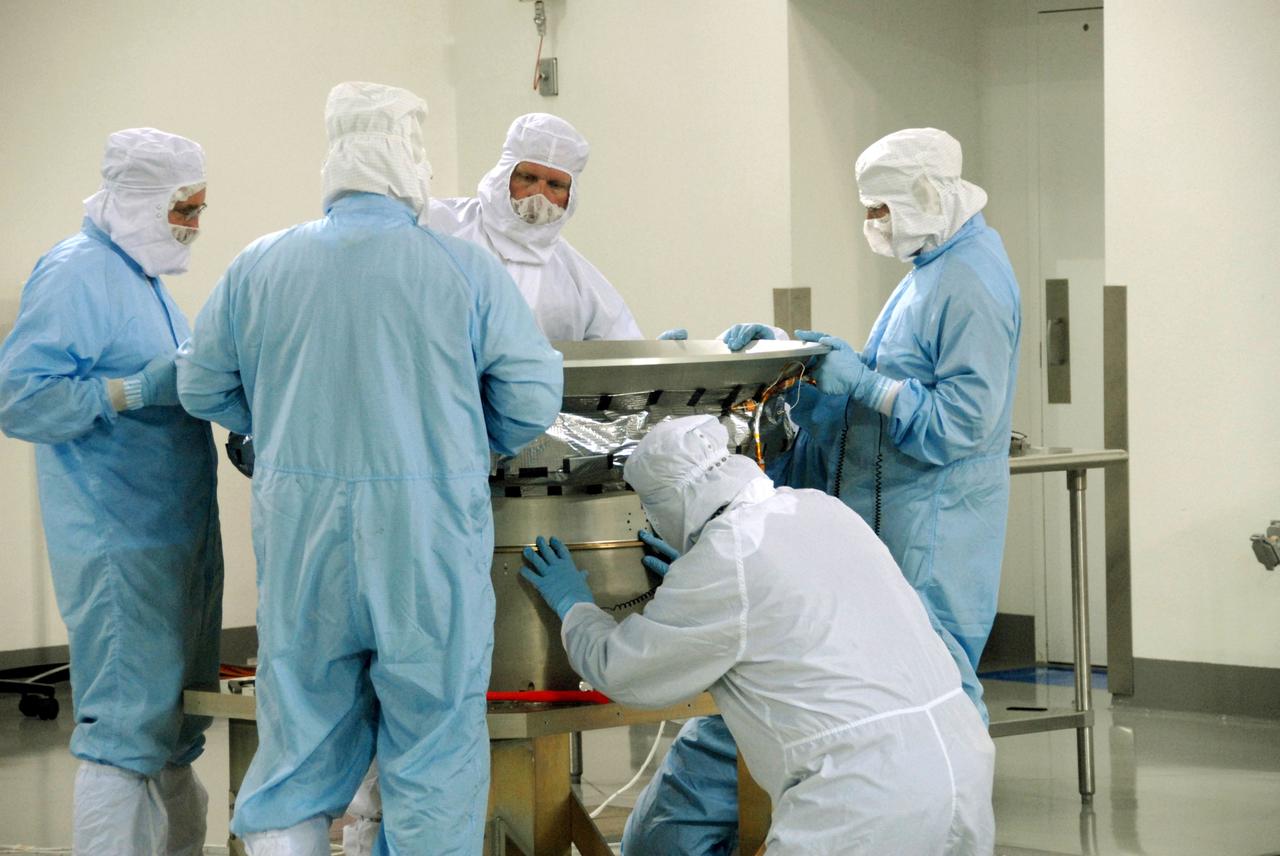 VANDENBERG AIR FORCE BASE, Calif. -- At Vandenberg Air Force Base's Astrotech processing facility in California, technicians working on NASA's Wide-field Infrared Survey Explorer, or WISE, spacecraft mate the flight conical adapter and soft ride to the test payload attach fitting clampband on the spacecraft test stand. The satellite will survey the entire sky at infrared wavelengths, creating a cosmic clearinghouse of hundreds of millions of objects, which will be catalogued, providing a vast storehouse of knowledge about the solar system, the Milky Way, and the universe. Launch is scheduled no earlier than Dec. 7. Photo credit: NASA/Doug Kolkow