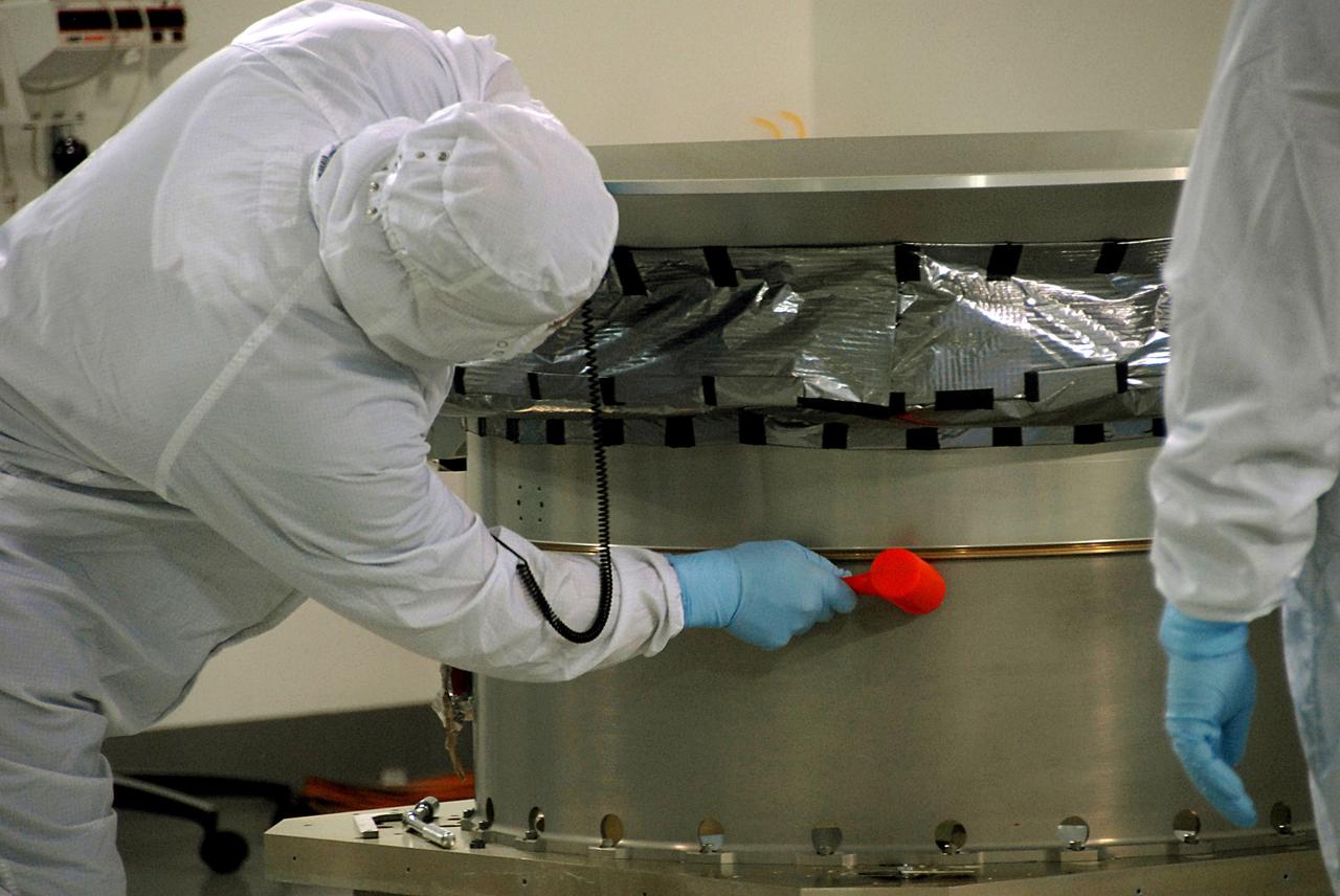VANDENBERG AIR FORCE BASE, Calif. -- At Vandenberg Air Force Base's Astrotech processing facility in California, a technician working on NASA's Wide-field Infrared Survey Explorer, or WISE, spacecraft uses a dead blow hammer to seat the clampband on the test payload attach fitting to complete the mating with the conical adapter. The satellite will survey the entire sky at infrared wavelengths, creating a cosmic clearinghouse of hundreds of millions of objects, which will be catalogued, providing a vast storehouse of knowledge about the solar system, the Milky Way, and the universe. Launch is scheduled no earlier than Dec. 7. Photo credit: NASA/Doug Kolkow