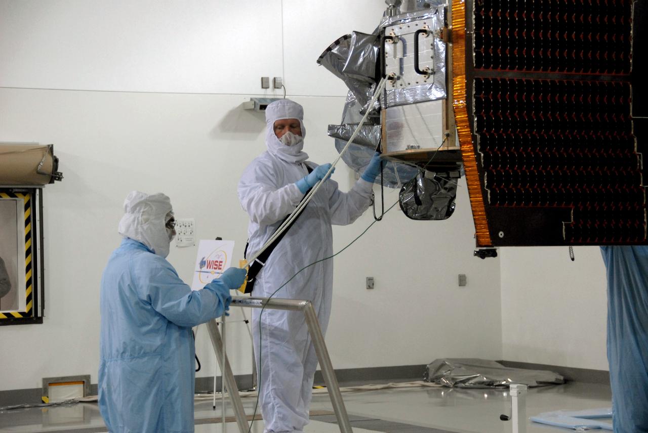 VANDENBERG AIR FORCE BASE, Calif. -- At Vandenberg Air Force Base's Astrotech processing facility in California, technicians help guide NASA's Wide-field Infrared Survey Explorer, or WISE, spacecraft to the flight conical adapter and test stand. The satellite will survey the entire sky at infrared wavelengths, creating a cosmic clearinghouse of hundreds of millions of objects, which will be catalogued, providing a vast storehouse of knowledge about the solar system, the Milky Way, and the universe. Launch is scheduled no earlier than Dec. 7. Photo credit: NASA/Doug Kolkow
