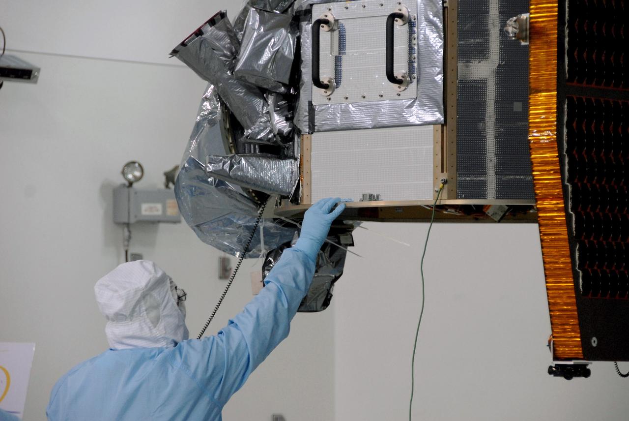 VANDENBERG AIR FORCE BASE, Calif. -- At Vandenberg Air Force Base's Astrotech processing facility in California, technicians help guide NASA's Wide-field Infrared Survey Explorer, or WISE, spacecraft to the flight conical adapter and test stand. The satellite will survey the entire sky at infrared wavelengths, creating a cosmic clearinghouse of hundreds of millions of objects, which will be catalogued, providing a vast storehouse of knowledge about the solar system, the Milky Way, and the universe. Launch is scheduled no earlier than Dec. 7. Photo credit: NASA/Doug Kolkow