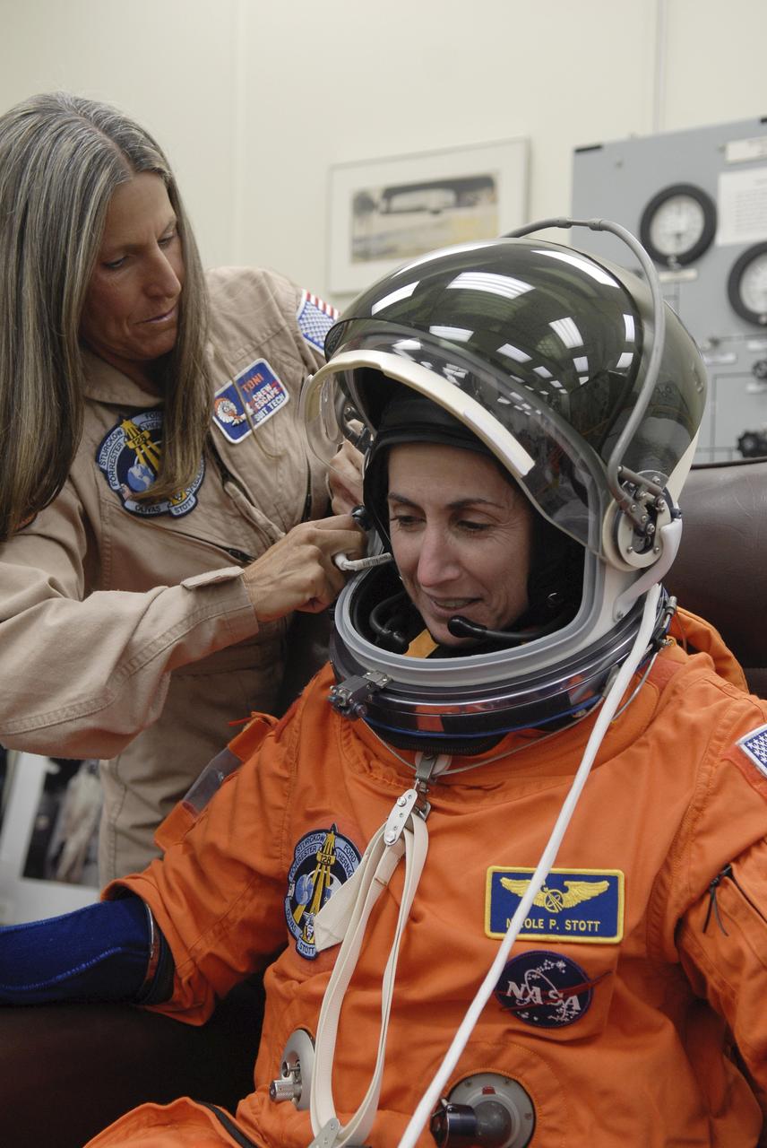 CAPE CANAVERAL, Fla. – In the Operations and Checkout Building at NASA's Kennedy Space Center in Florida, STS-128 crew members put on their launch-and-entry suits before heading to the Astrovan for the 3.4-mile drive to Launch Pad 39A. There, crew members will complete their suit-up and enter space shuttle Discovery for the 11:59 p.m. EDT liftoff. Here, Mission Specialist Nicole Stott is helped with her helmet. The first launch attempt on Aug. 24 was postponed due to unfavorable weather conditions. The second attempt on Aug. 25 also was postponed due to an issue with a valve in space shuttle Discovery's main propulsion system. The 13-day mission will deliver more than 7 tons of supplies, science racks and equipment, as well as additional environmental hardware to sustain six crew members on the International Space Station. The equipment includes a freezer to store research samples, a new sleeping compartment and the COLBERT treadmill. The mission is the 128th in the Space Shuttle Program, the 37th flight of Discovery and the 30th station assembly flight. Photo credit: NASA/Kim Shiflett