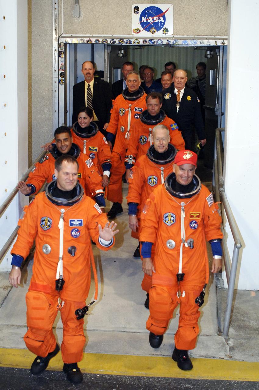 CAPE CANAVERAL, Fla. – The STS-128 crew members eagerly exit NASA Kennedy Space Center's Operations and Checkout Building to head to the Astrovan for the 3.4-mile drive to Launch Pad 39A. Clockwise from left are Pilot Kevin Ford, Mission Specialists Jose Fernandez, Nicole Stott, Danny Olivas, Christer Fuglesang and Patrick Forrester, and Commander Rick Sturckow. At the pad, the astronauts will complete their suit-up and enter space shuttle Discovery for the 11:59 p.m. EDT liftoff. The first launch attempt on Aug. 24 was postponed due to unfavorable weather conditions. The second attempt on Aug. 25 also was postponed due to an issue with a valve in space shuttle Discovery's main propulsion system. The 13-day mission will deliver more than 7 tons of supplies, science racks and equipment, as well as additional environmental hardware to sustain six crew members on the International Space Station. The equipment includes a freezer to store research samples, a new sleeping compartment and the COLBERT treadmill. The mission is the 128th in the Space Shuttle Program, the 37th flight of Discovery and the 30th station assembly flight. Photo credit: NASA/Kim Shiflett