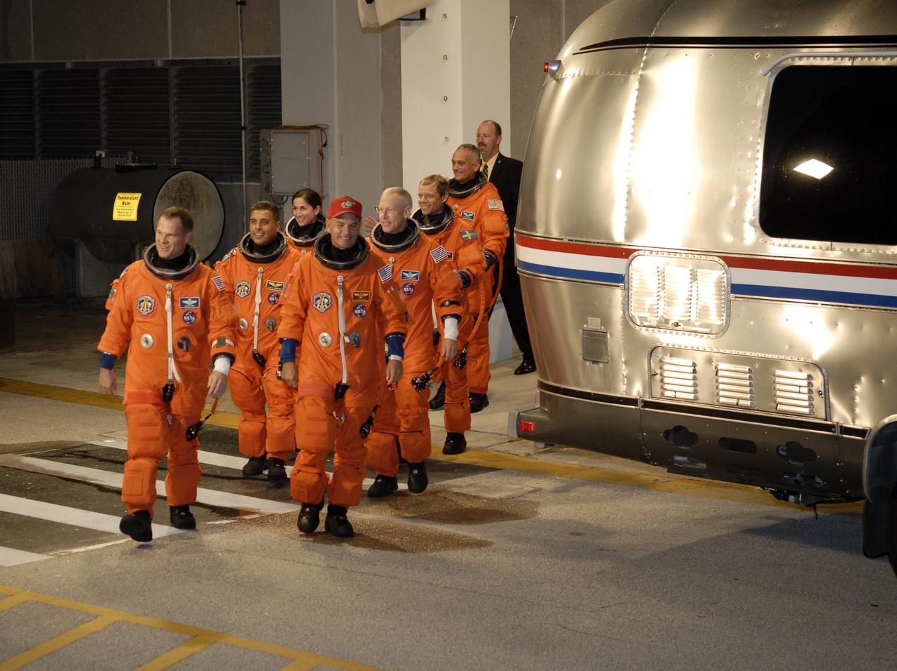 CAPE CANAVERAL, Fla. – The STS-128 crew members turn toward the Astrovan after exiting NASA Kennedy Space Center's Operations and Checkout Building. The vehicle will take them to Launch Pad 39A. From left are Pilot Kevin Ford, Mission Specialists Jose Fernandez and Nicole Stott, Commander Rick Sturckow, and Mission Specialists Patrick Forrester, Christer Fuglesang and Danny Olivas. At the pad, the astronauts will complete their suit-up and enter space shuttle Discovery for the 11:59 p.m. EDT liftoff. The first launch attempt on Aug. 24 was postponed due to unfavorable weather conditions. The second attempt on Aug. 25 also was postponed due to an issue with a valve in space shuttle Discovery's main propulsion system. The 13-day mission will deliver more than 7 tons of supplies, science racks and equipment, as well as additional environmental hardware to sustain six crew members on the International Space Station. The equipment includes a freezer to store research samples, a new sleeping compartment and the COLBERT treadmill. The mission is the 128th in the Space Shuttle Program, the 37th flight of Discovery and the 30th station assembly flight. Photo credit: NASA/Kim Shiflett