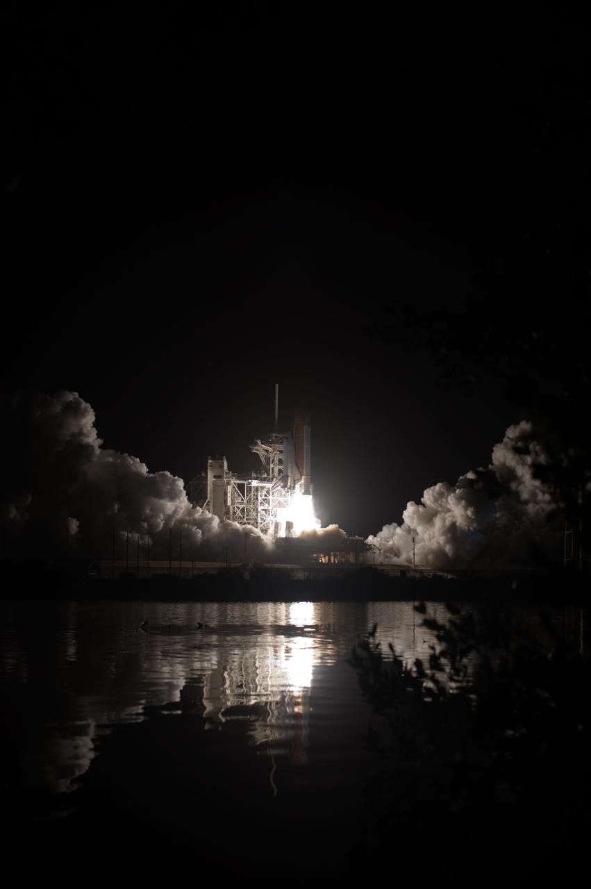 CAPE CANAVERAL, Fla. – The fiery liftoff of space shuttle Discovery at NASA's Kennedy Space Center in Florida is captured in the water close to Launch Pad 39A. Liftoff on the STS-128 mission was on time at 11:59 p.m. EDT. The first launch attempt on Aug. 24 was postponed due to unfavorable weather conditions. The second attempt on Aug. 25 also was postponed due to an issue with a valve in space shuttle Discovery's main propulsion system. The STS-128 mission is the 30th International Space Station assembly flight and the 128th space shuttle flight. The 13-day mission will deliver more than 7 tons of supplies, science racks and equipment, as well as additional environmental hardware to sustain six crew members on the International Space Station. The equipment includes a freezer to store research samples, a new sleeping compartment and the COLBERT treadmill. Photo credit: NASA/Tony Gray-Tom Farrar