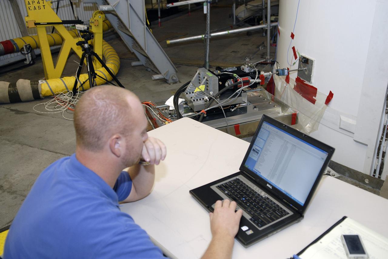 CAPE CANAVERAL, Fla. – In the Vehicle Assembly Building's High Bay 4 at NASA's Kennedy Space Center in Florida, a worker monitors data collected during a sway test on the Ares I-X launch vehicle. The test is simulating conditions the rocket could experience during rollout to Launch Pad 39B, wind conditions at the pad and first-stage ignition. During the test, vibrations are mechanically induced into the rocket by four hydraulic shakers and a sway is manually introduced for lateral motion to measure the vehicle's response. A total of 44 accelerometers are installed on the flight test vehicle that required more than 27,000 feet of cable. Part of the Constellation Program, the Ares I-X is the test vehicle for the Ares I, which is the essential core of a space transportation system that eventually will carry crewed missions back to the moon, on to Mars and out into the solar system . The Ares I-X flight test is targeted for Oct. 31. Photo credit: NASA/Kim Shiflett