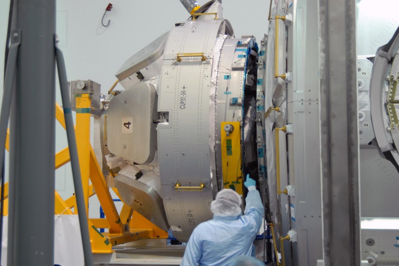 CAPE CANAVERAL, Fla. – In the Space Station Processing Facility at NASA's Kennedy Space Center in Florida, a worker checks the alignment of the Cupola module, at left, with the Tranquility module, at right. Cupola and Tranquility are the payload for space shuttle Endeavour's STS-130 mission to the International Space Station. The module was built for the European Space Agency by Alenia Spazio in Turin, Italy. When attached to the Tranquility Node 3 module, Cupola will resemble a circular bay window that will provide a vastly improved view of the station's exterior. Just under 10 feet in diameter, the module will accommodate two crew members and portable workstations that can control station and robotic activities. The multi-directional view will allow the crew to monitor spacewalks and docking operations, as well as provide a spectacular view of Earth and other celestial objects. Endeavour is targeted to launch Feb. 4, 2010. Photo credit: NASA/Jim Grossmann