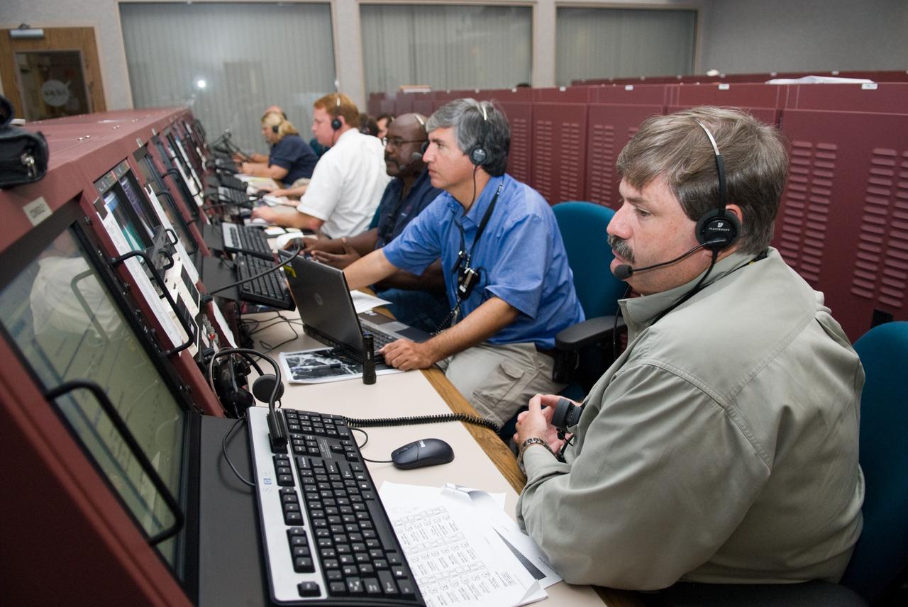 CAPE CANAVERAL, Fla. – In the Launch Vehicle Data Center- 1 in Cape Canaveral Air Force Station's Hangar AE, (from right) JJ Joyner, Jonathan Cruz and Stuart Cooke take part in a countdown simulation for the upcoming Ares I-X flight test. The LVDC was developed by NASA's Kennedy Space Center to support multiple test operations in parallel or a single large launch operation. The LVDC works in tandem with the adjacent Mission Director Center, the control room where NASA launch managers monitor expendable vehicle launches, and where the final decision to launch is made. Photo credit: NASA/Kim Shiflett