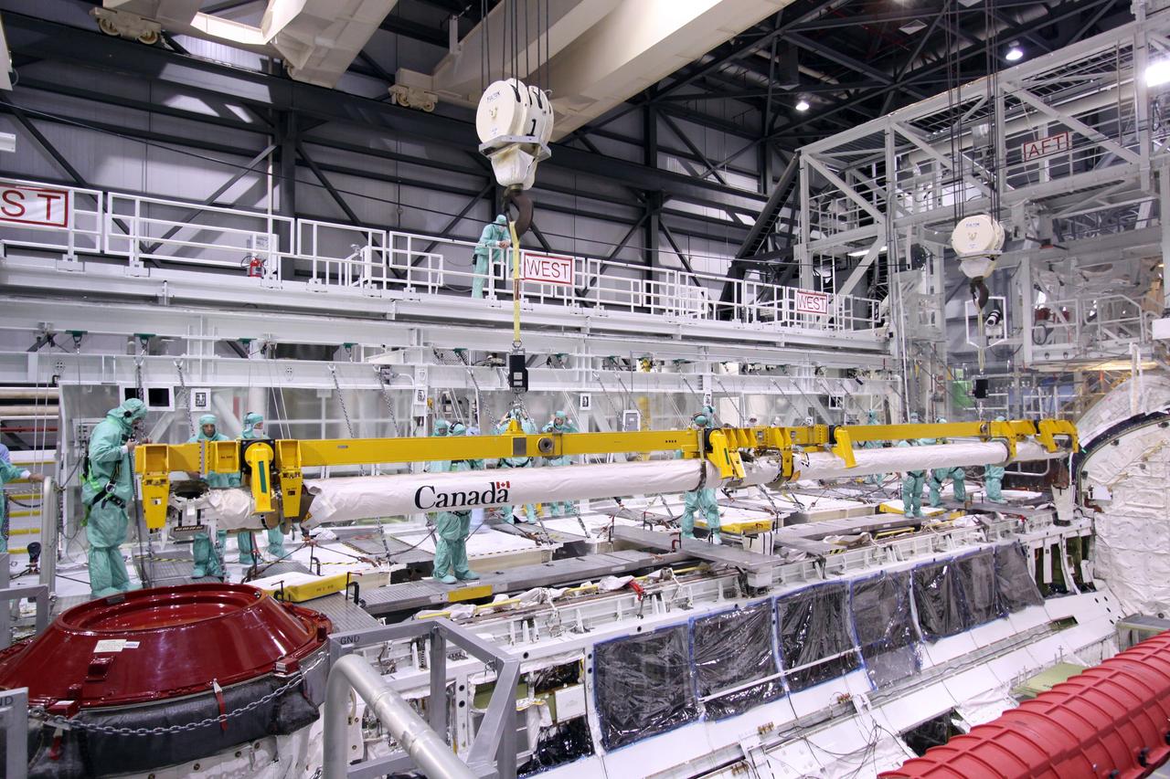 CAPE CANAVERAL, Fla. – In NASA Kennedy Space Center's Orbiter Processing Facility bay 2, a crane lowers space shuttle Endeavour's Orbiter Boom Sensor System toward the payload bay for reinstallation. The OBSS is a 50-foot boom with a laser and cameras on it that astronauts use to inspect a shuttle's heat shield while in orbit. After returning from the STS-127 mission July 31, 2009, Endeavour now is being processed for the STS-130 mission targeted for Feb. 4, 2010. Endeavour will deliver to the International Space Station the Tranquility pressurized module that will provide room for many of the station's life support systems. Photo credit: NASA/Jack Pfaller