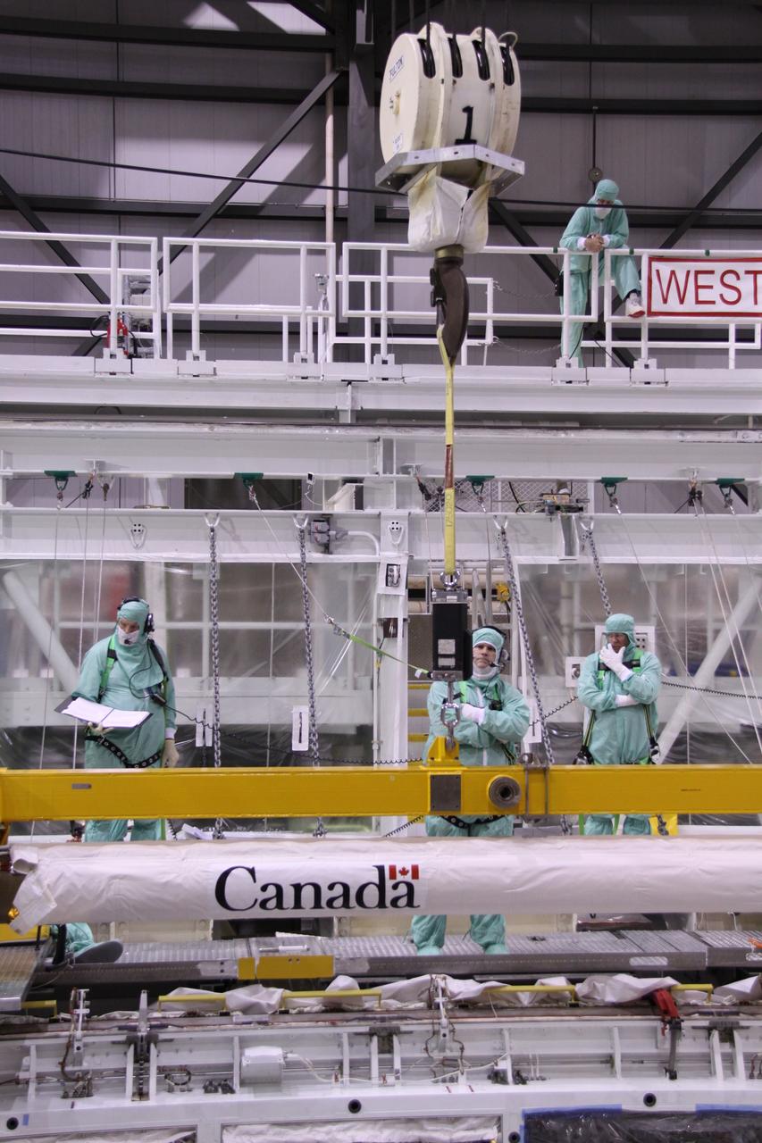 CAPE CANAVERAL, Fla. – In NASA Kennedy Space Center's Orbiter Processing Facility bay 2, workers check the movement of space shuttle Endeavour's Orbiter Boom Sensor System as it is lowered into the payload bay. The OBSS is being reinstalled in the payload bay. The OBSS is a 50-foot boom with a laser and cameras on it that astronauts use to inspect a shuttle's heat shield while in orbit. After returning from the STS-127 mission July 31, 2009, Endeavour now is being processed for the STS-130 mission targeted for Feb. 4, 2010. Endeavour will deliver to the International Space Station the Tranquility pressurized module that will provide room for many of the station's life support systems. Photo credit: NASA/Jack Pfaller