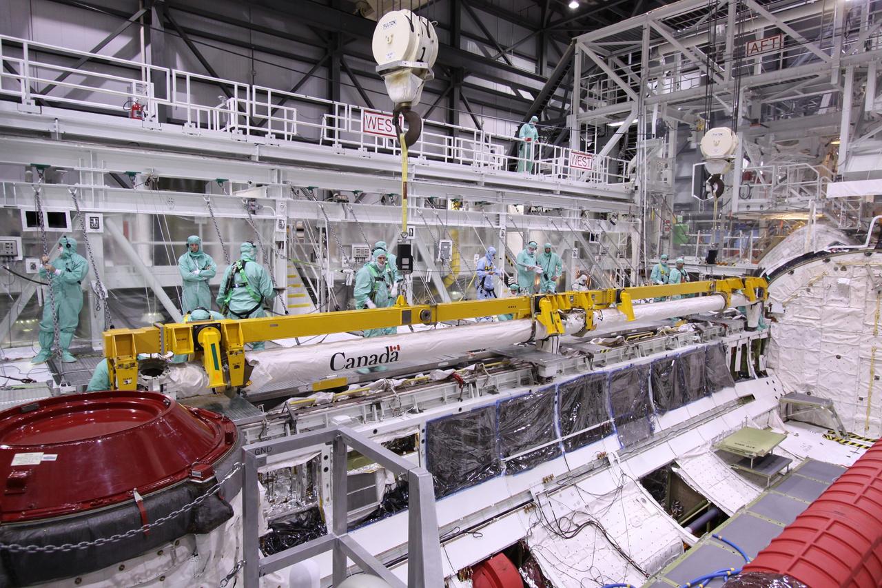 CAPE CANAVERAL, Fla. – In NASA Kennedy Space Center's Orbiter Processing Facility bay 2, workers check the movement of space shuttle Endeavour's Orbiter Boom Sensor System as it is lowered into the payload bay. The OBSS is being reinstalled in the payload bay. The OBSS is being reinstalled in the payload bay. The OBSS is a 50-foot boom with a laser and cameras on it that astronauts use to inspect a shuttle's heat shield while in orbit. After returning from the STS-127 mission July 31, 2009, Endeavour now is being processed for the STS-130 mission targeted for Feb. 4, 2010. Endeavour will deliver to the International Space Station the Tranquility pressurized module that will provide room for many of the station's life support systems. Photo credit: NASA/Jack Pfaller