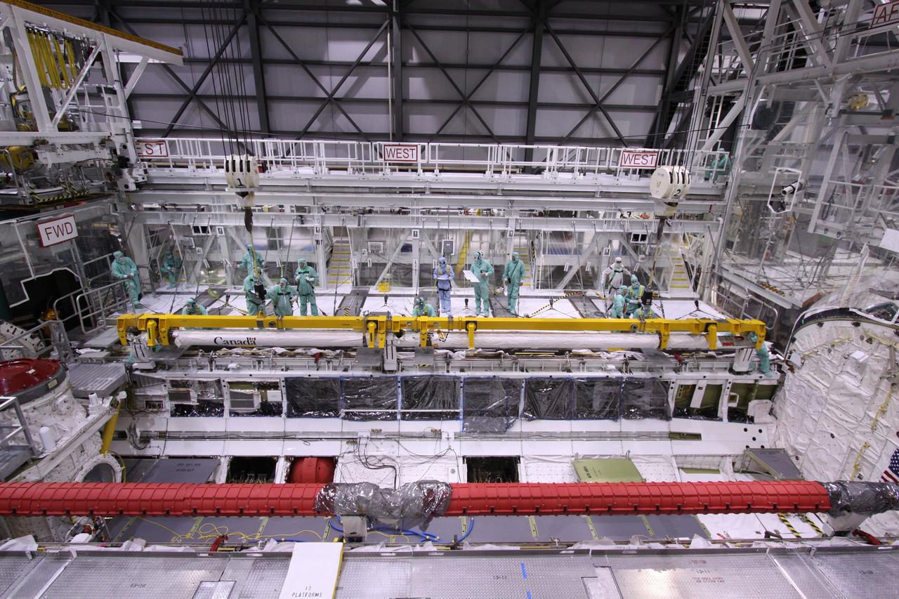 CAPE CANAVERAL, Fla. – In NASA Kennedy Space Center's Orbiter Processing Facility bay 2, space shuttle Endeavour's Orbiter Boom Sensor System is lowered into position in the shuttle's payload bay. The OBSS is being reinstalled in the payload bay. The OBSS is being reinstalled in the payload bay. The OBSS is a 50-foot boom with a laser and cameras on it that astronauts use to inspect a shuttle's heat shield while in orbit. After returning from the STS-127 mission July 31, 2009, Endeavour now is being processed for the STS-130 mission targeted for Feb. 4, 2010. Endeavour will deliver to the International Space Station the Tranquility pressurized module that will provide room for many of the station's life support systems. Photo credit: NASA/Jack Pfaller