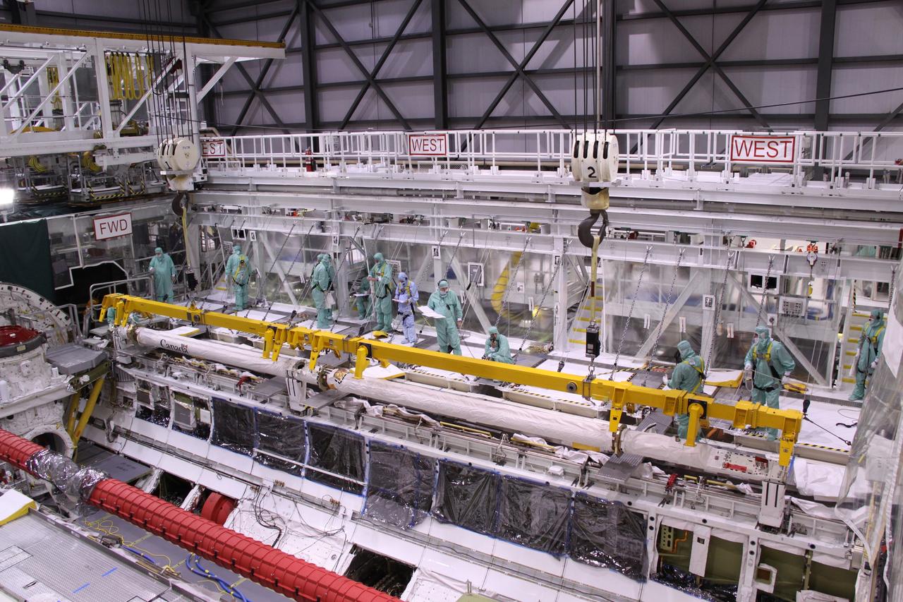 CAPE CANAVERAL, Fla. – In NASA Kennedy Space Center's Orbiter Processing Facility bay 2, space shuttle Endeavour's Orbiter Boom Sensor System is lowered into position in the shuttle's payload bay. The OBSS is being reinstalled in the payload bay. The OBSS is being reinstalled in the payload bay. The OBSS is a 50-foot boom with a laser and cameras on it that astronauts use to inspect a shuttle's heat shield while in orbit. After returning from the STS-127 mission July 31, 2009, Endeavour now is being processed for the STS-130 mission targeted for Feb. 4, 2010. Endeavour will deliver to the International Space Station the Tranquility pressurized module that will provide room for many of the station's life support systems. Photo credit: NASA/Jack Pfaller
