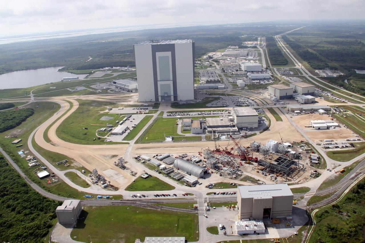 CAPE CANAVERAL, Fla. – This aerial view shows the heart of NASA Kennedy Space Center's Launch Complex 39 Area with the 525-foot tall Vehicle Assembly Building dominating. At lower right is the mobile launcher parking area where the new mobile launcher, or ML, for the Ares rockets is under construction. The ML will be the base to launch the Orion crew exploration vehicle and the cargo vehicle. The base is being made lighter than space shuttle mobile launcher platforms so the crawler-transporter can pick up the added load of the 345-foot tower and taller rocket. When the structural portion of the new mobile launcher is complete, umbilicals, access arms, communications equipment and command/control equipment will be installed. Photo credit: NASA/Troy Cryder