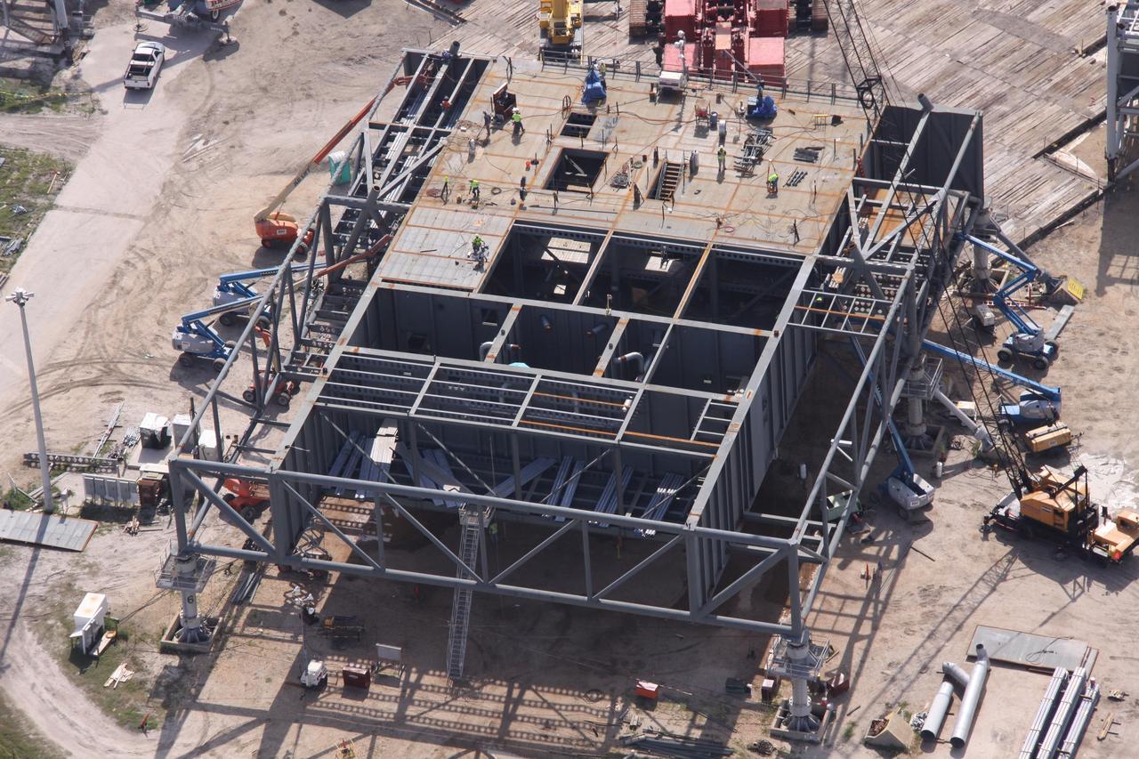 CAPE CANAVERAL, Fla. – This aerial view shows the new mobile launcher, or ML, under construction at NASA's Kennedy Space Center in Florida. The launcher is being built for the Ares rockets. The ML will be the base to launch the Orion crew exploration vehicle and the cargo vehicle. The base is being made lighter than space shuttle mobile launcher platforms so the crawler-transporter can pick up the added load of the 345-foot tower and taller rocket. When the structural portion of the new mobile launcher is complete, umbilicals, access arms, communications equipment and command/control equipment will be installed. Photo credit: NASA/Troy Cryder