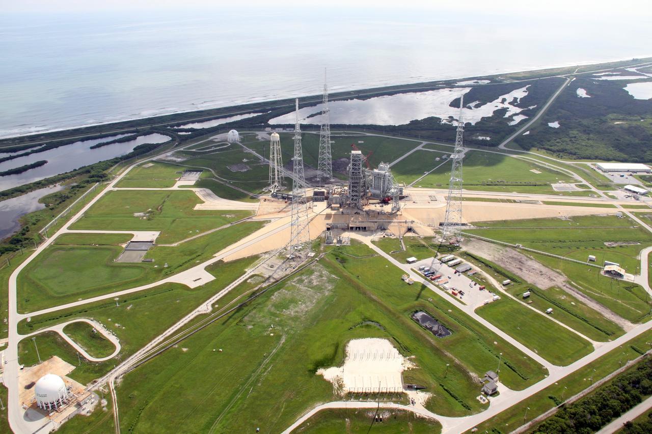 CAPE CANAVERAL, Fla. – An aerial view of NASA Kennedy Space Center's Launch Pad 39B. The pad is surrounded by lightning towers erected for NASA's Constellation Program, which will use the pad for Ares rocket launches. At the top is the Atlantic Ocean. Photo credit: NASA/Troy Cryder